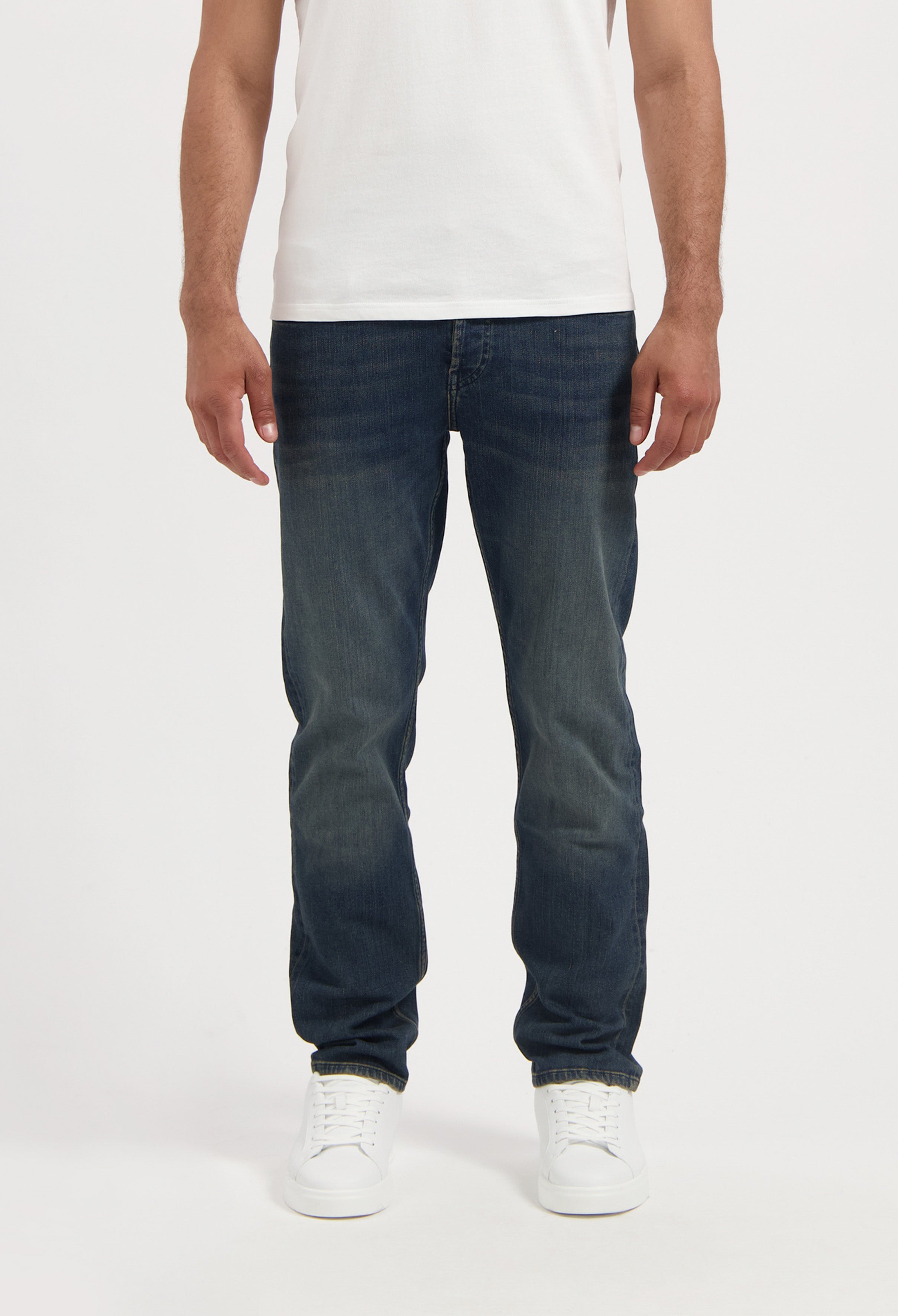 Sustainable MUD Jeans in light blue denim, crafted ethically from organic cotton, shown with black t-shirt and shoes.