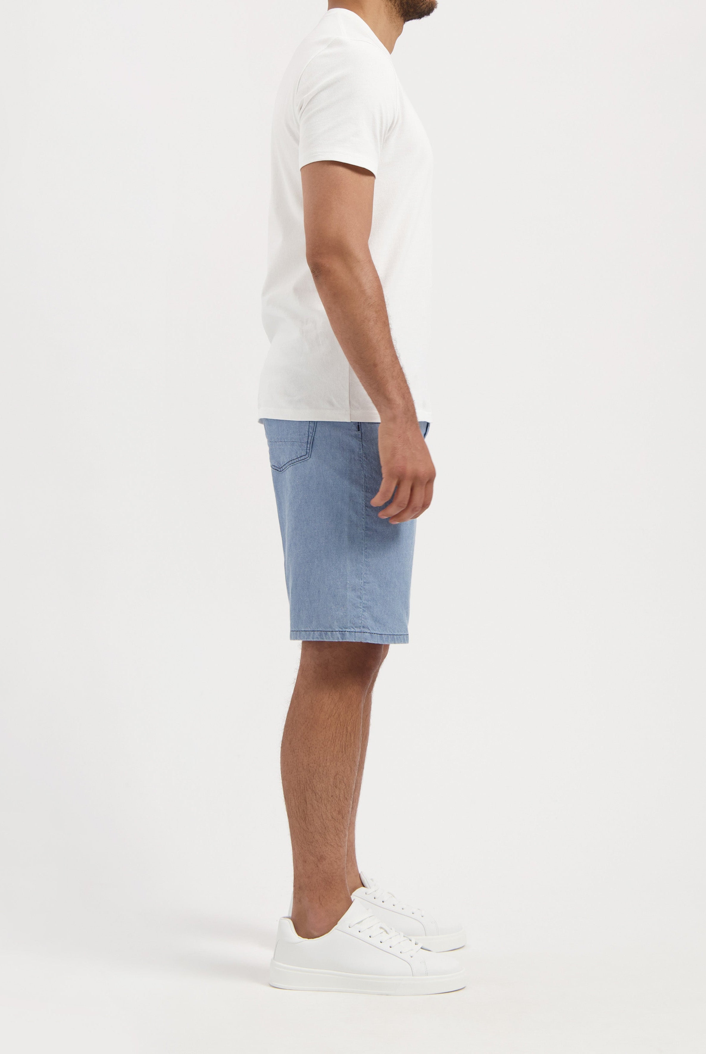 Sustainable MUD Jeans in deep blue denim, crafted from organic cotton, paired with a light gray sweater for an eco-friendly look.