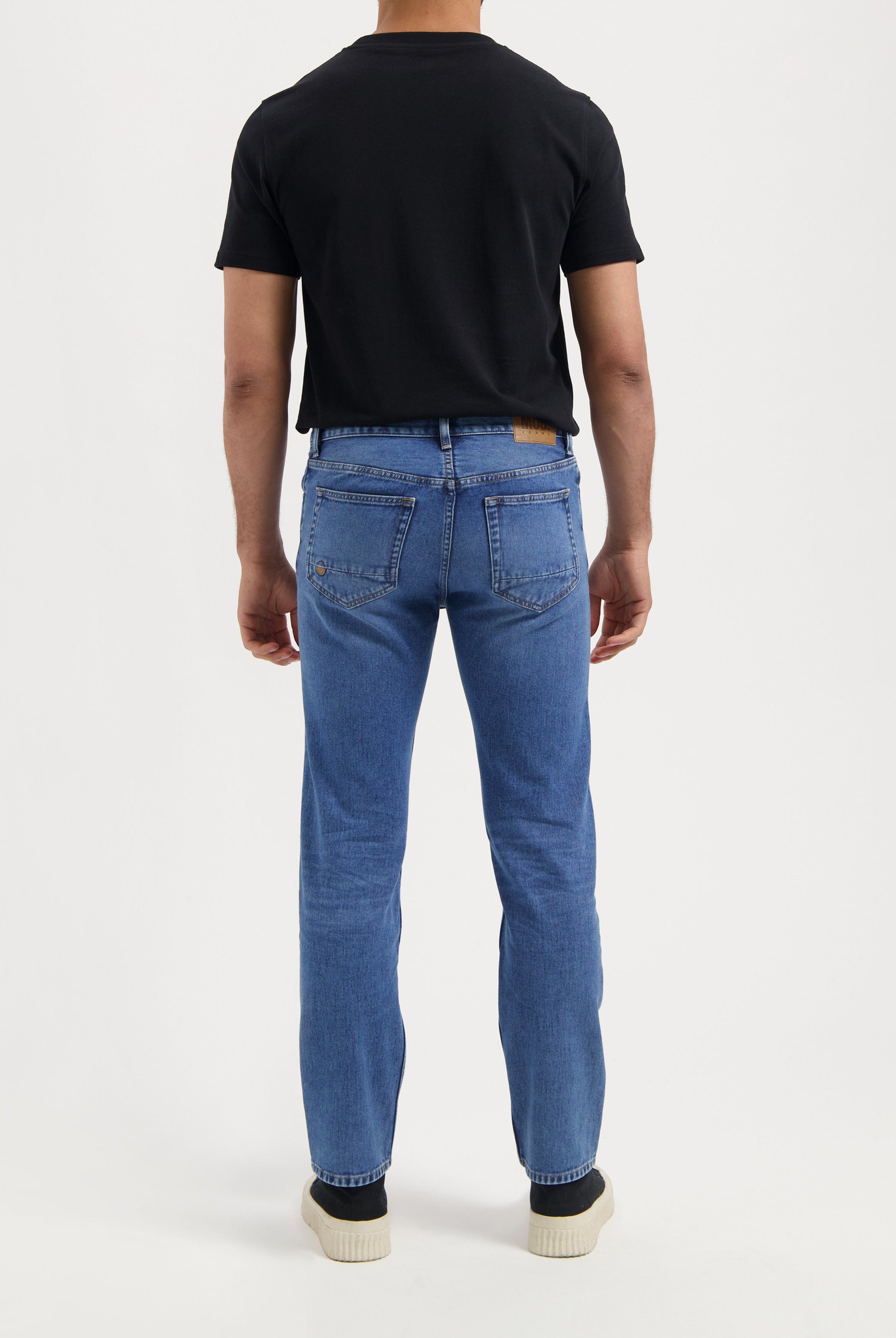 Sustainable MUD Jeans with a relaxed fit in black denim, crafted ethically for eco-friendly fashion, paired with a clean white tee.