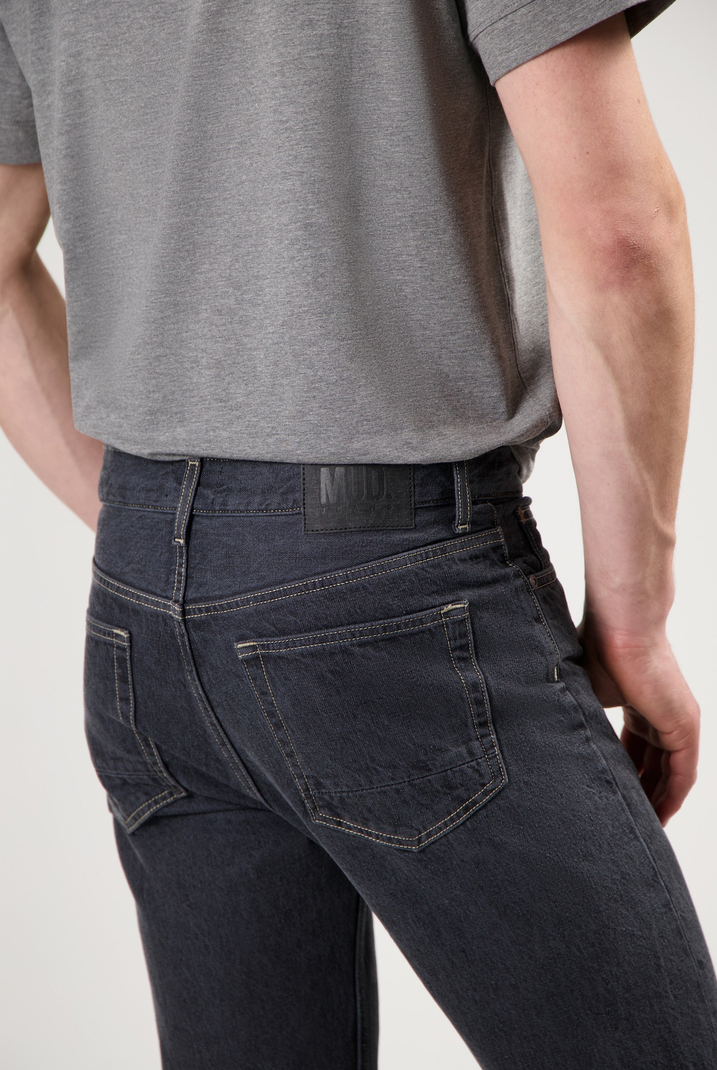 Sustainable black MUD Jeans crafted from organic cotton, paired with a cozy white sweater for ethical fashion style.