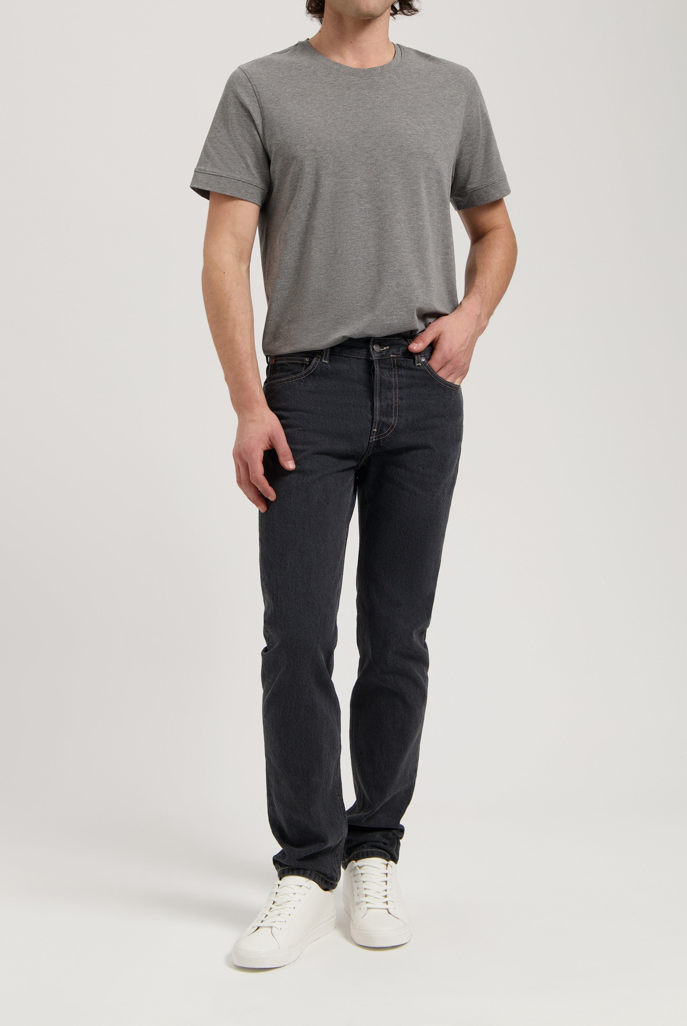 Sustainable MUD Jeans in black denim, paired with an ethical cream knit sweater, showcasing eco-friendly fashion.