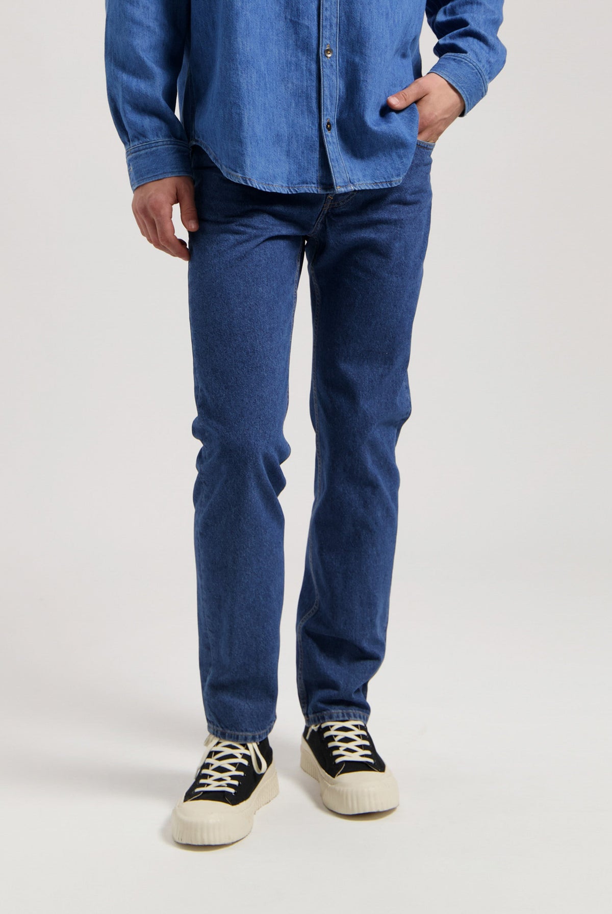 Sustainable MUD Jeans in dark blue denim, crafted ethically, paired with white shirt, showcasing classic fit style.