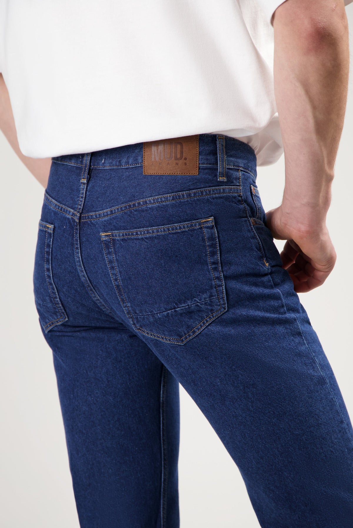 Sustainable MUD Jeans outfit in blue denim featuring an ethical shirt and classic fit jeans, paired with white sneakers.