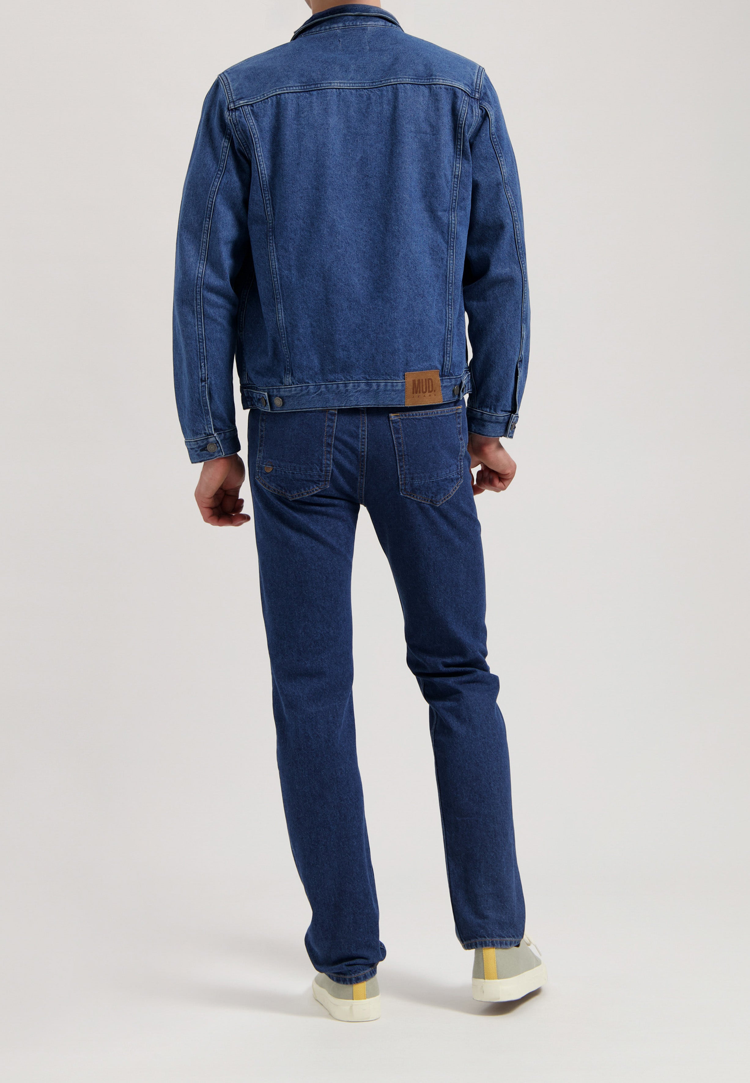 Sustainable MUD Jeans in dark blue, crafted from organic materials, offering an ethical fit with minimalist pockets.