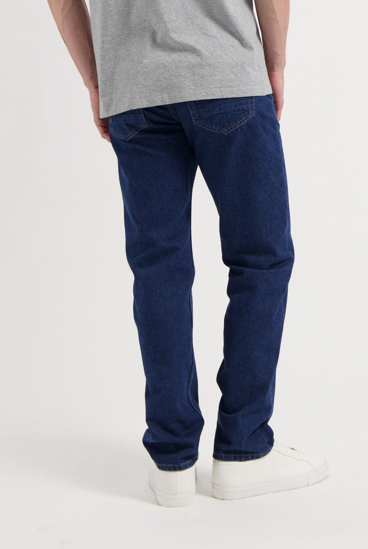 Sustainable MUD Jeans denim set in classic fit, featuring eco-friendly blue fabric and white sneakers.