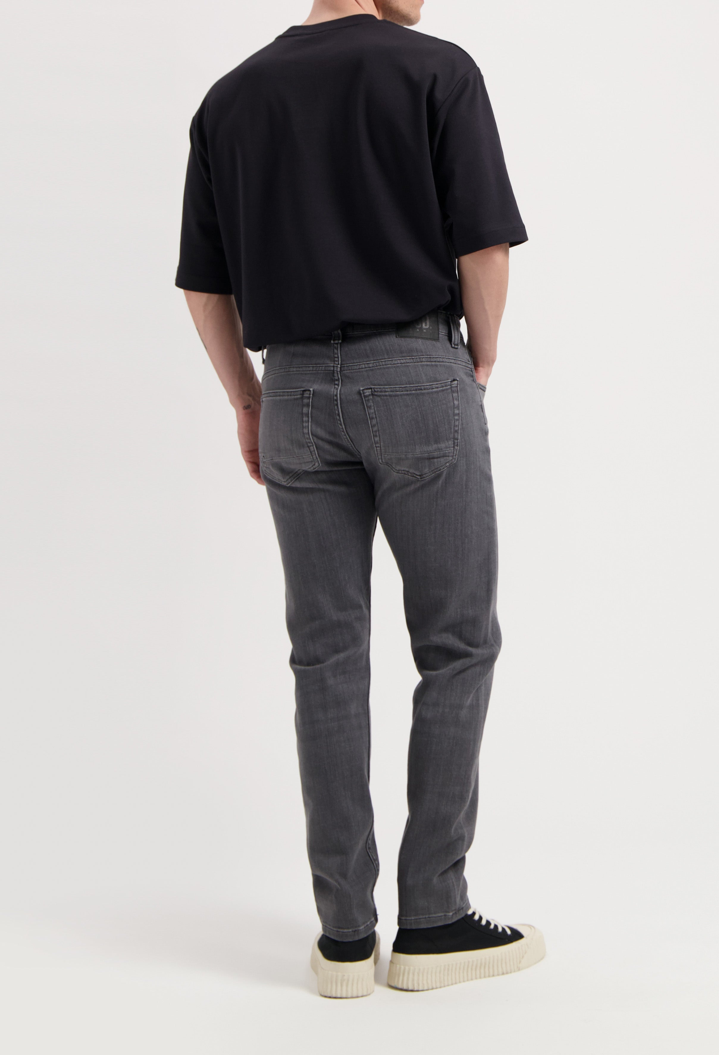 Ethical MUD Jeans in dark blue denim, offering a sustainable choice with a straight fit, styled with a gray tee.