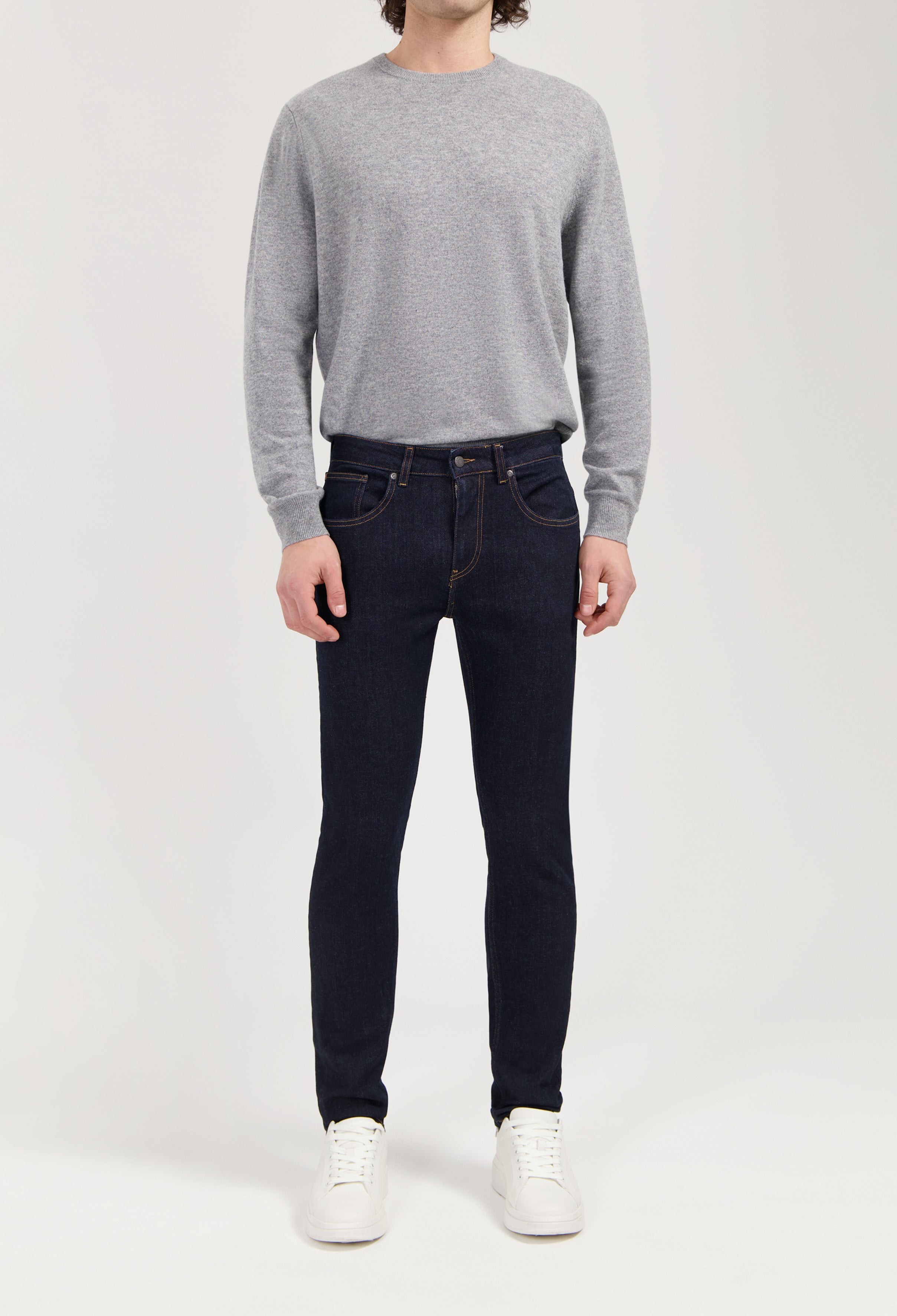 Sustainable MUD Jeans in light blue denim, crafted from organic cotton, styled with a white t-shirt and sneakers.