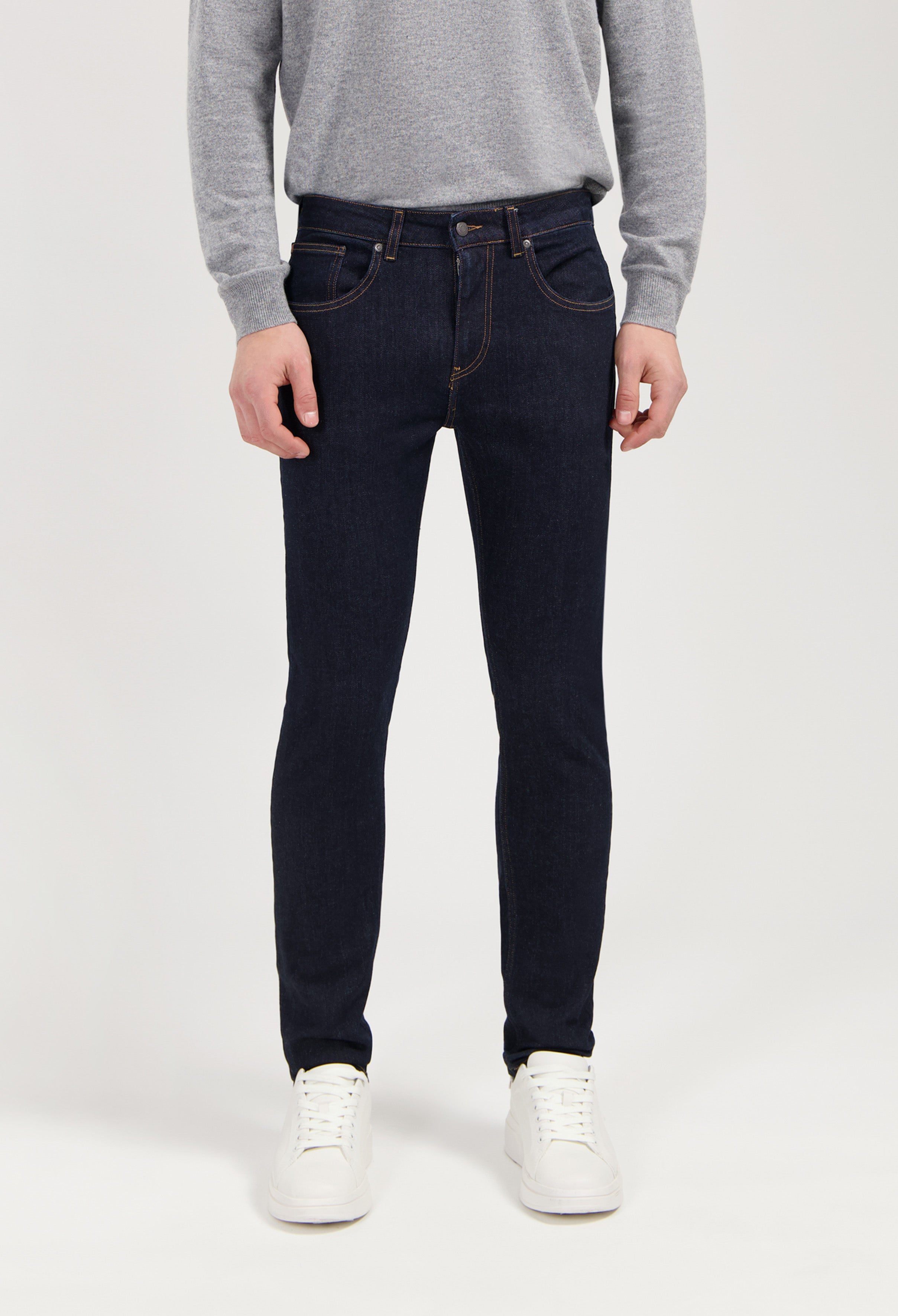 Sustainable MUD Jeans in classic fit, featuring ethical light blue denim, worn with a white shirt.