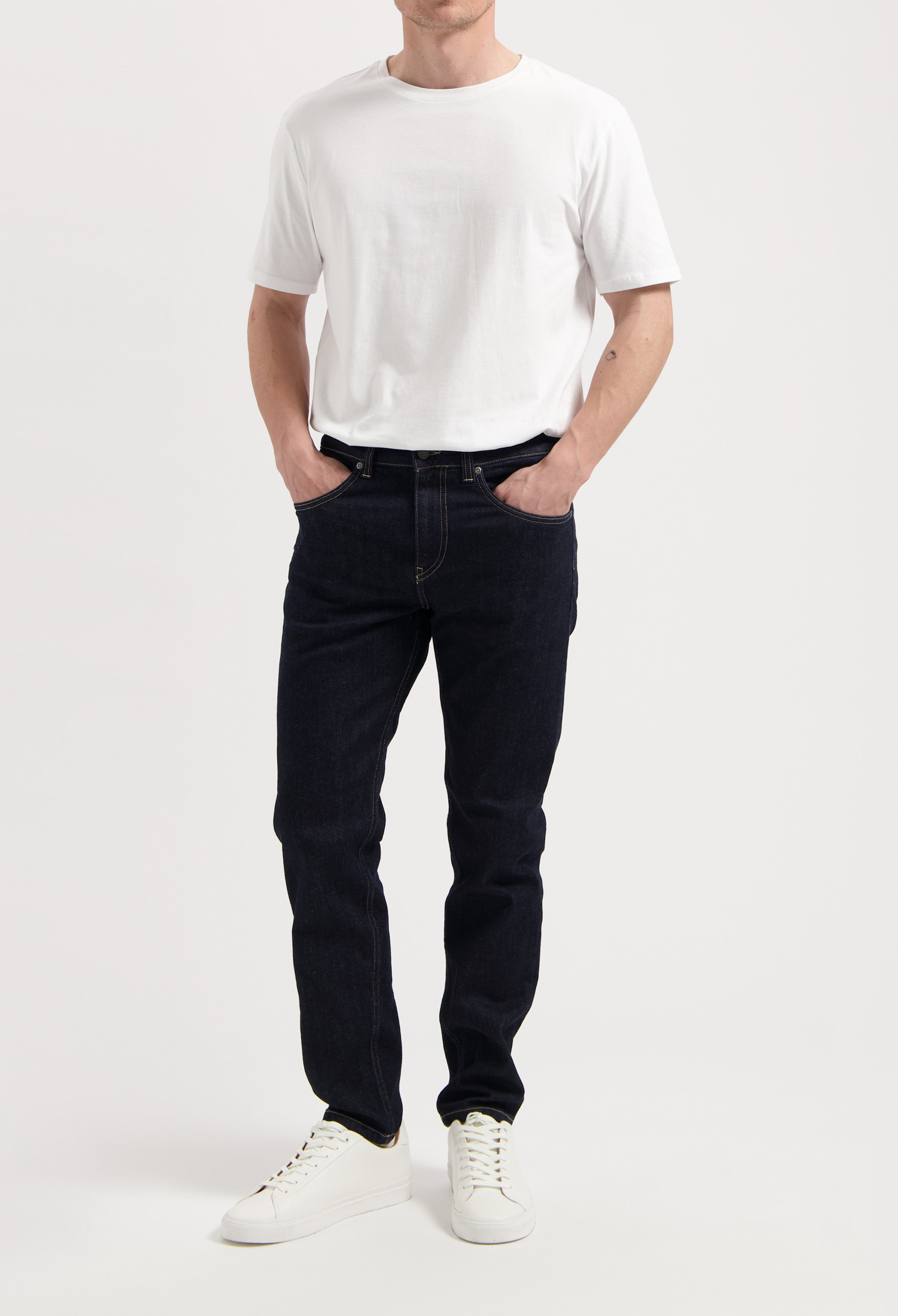 Sustainable MUD Jeans made from organic cotton in classic blue denim, paired with a gray sweater for an ethical style.