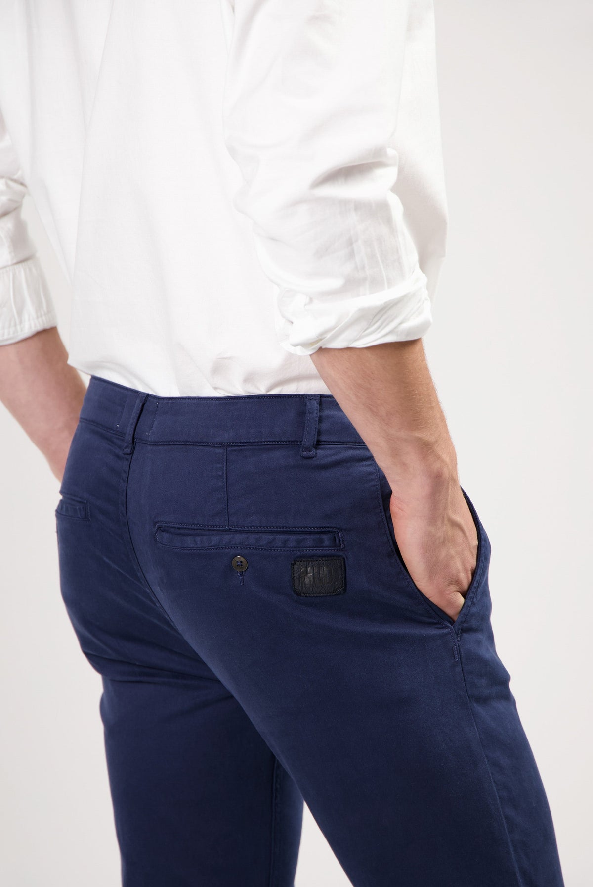 Sustainable MUD Jeans in dark gray denim, crafted ethically, showcasing a slim fit style paired with black sneakers.