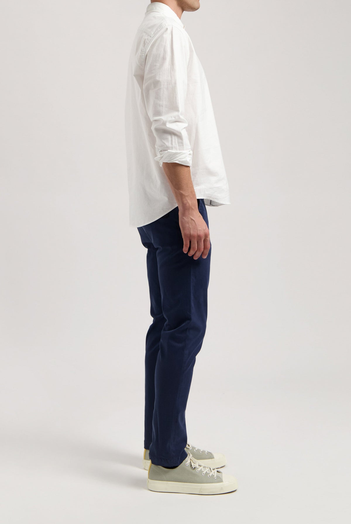 Sustainable MUD Jeans in gray denim, crafted ethically, paired with a black t-shirt and casual black sneakers.