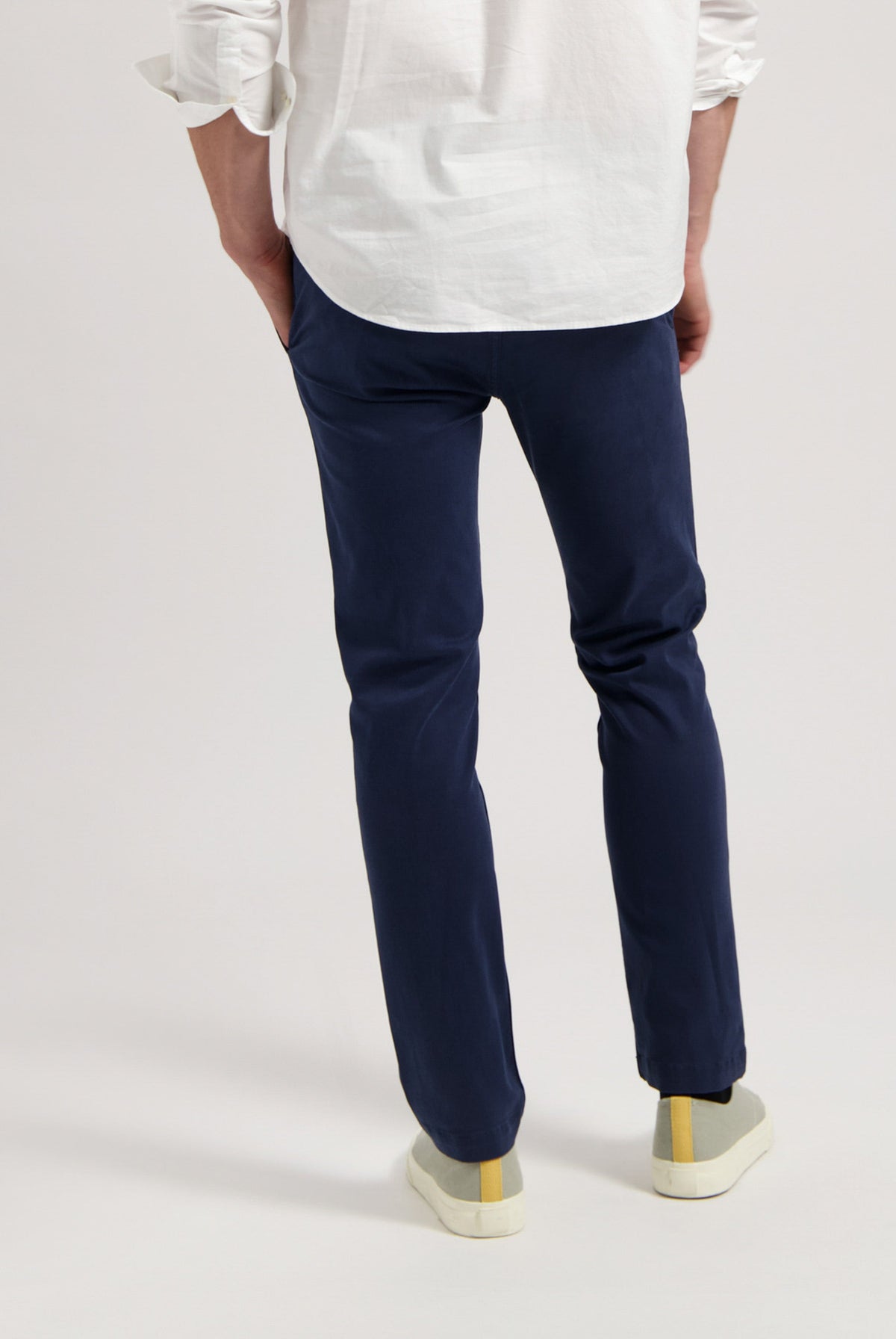 Sustainable MUD Jeans in dark gray denim, made from organic cotton, paired with black sneakers for an ethical look.