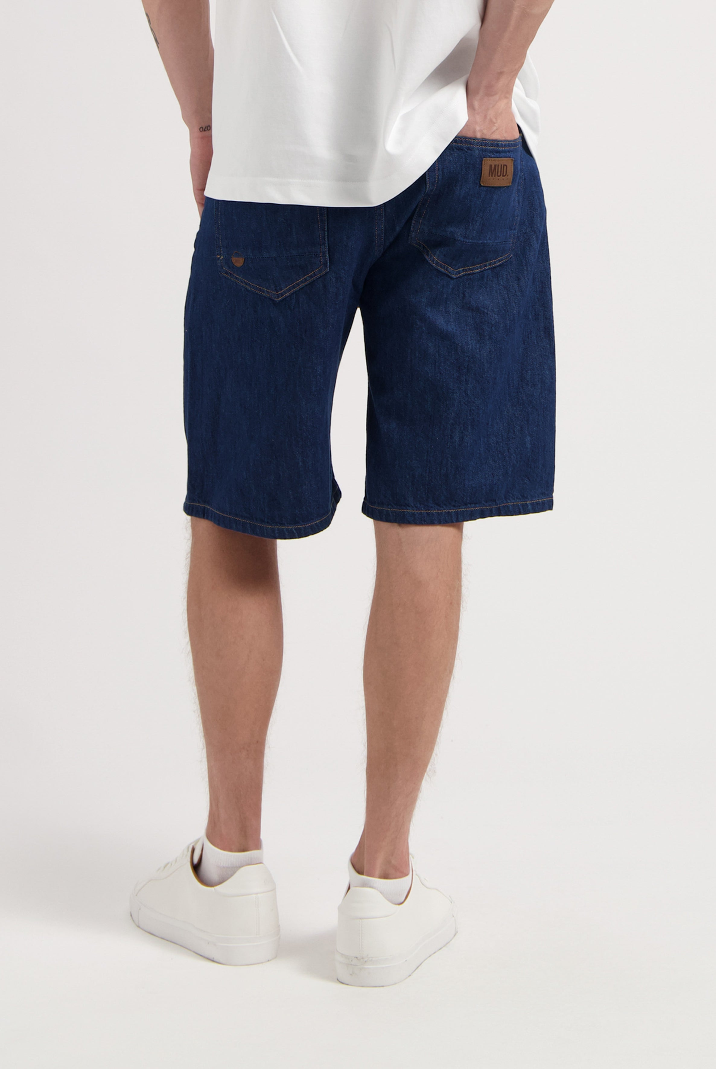 Sustainable MUD Jeans in light blue organic cotton, classic fit, paired with a simple white t-shirt for ethical fashion.