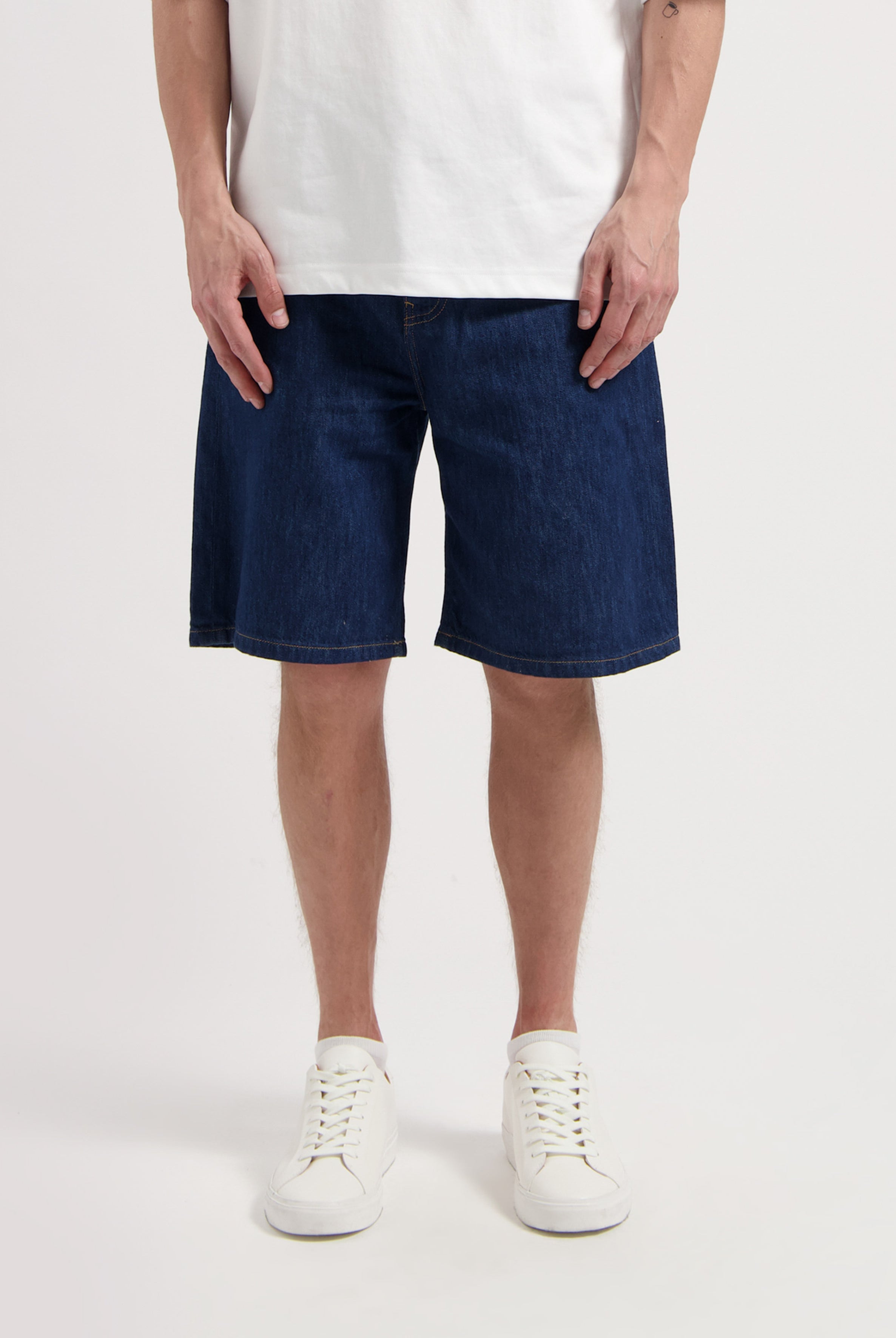 Sustainable MUD Jeans made from organic cotton, featuring light blue denim in a straight fit, paired with casual sneakers.