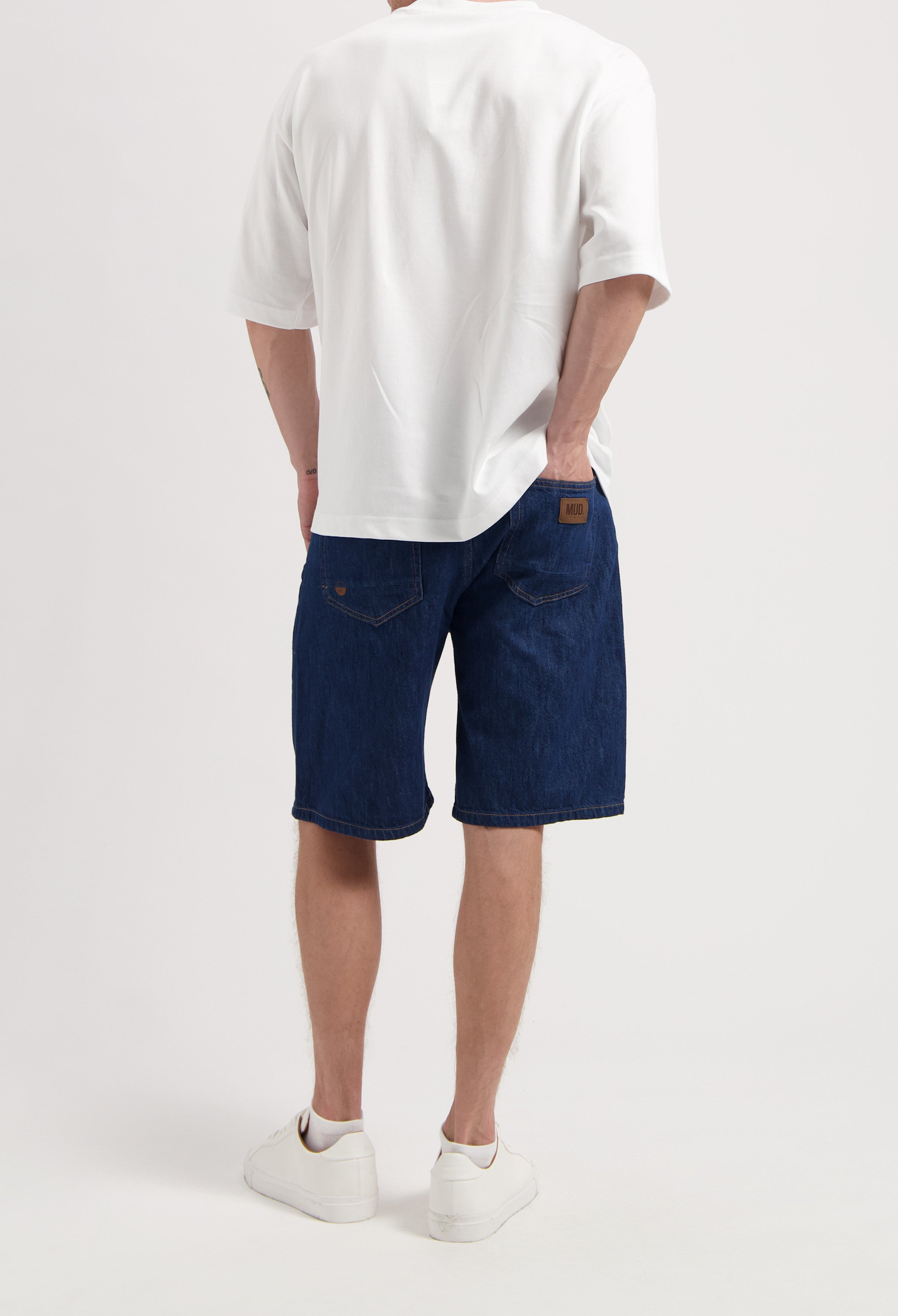 Sustainable MUD Jeans in light blue denim, crafted ethically from organic cotton, paired with a gray t-shirt.