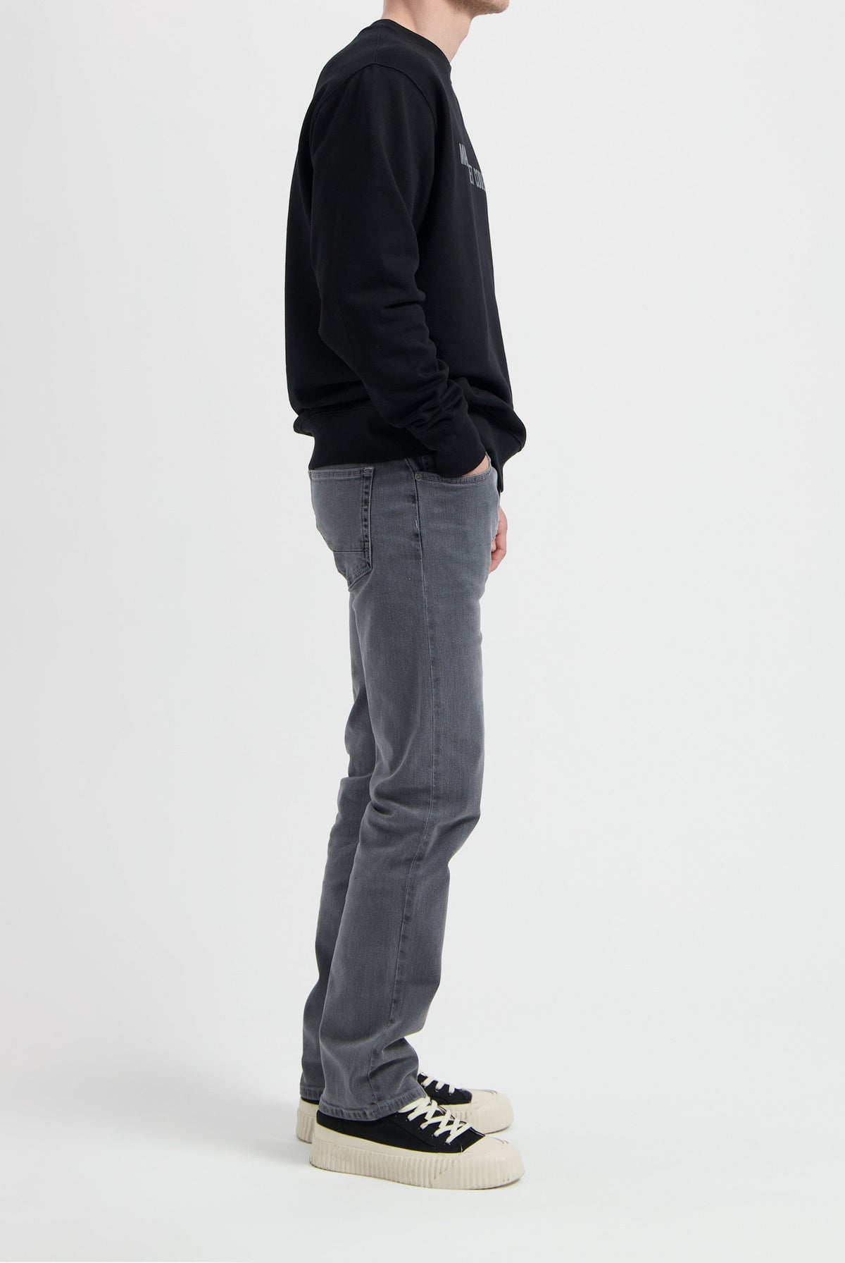 Sustainable MUD Jeans in light blue denim, crafted ethically from organic cotton, shown paired with white sneakers.