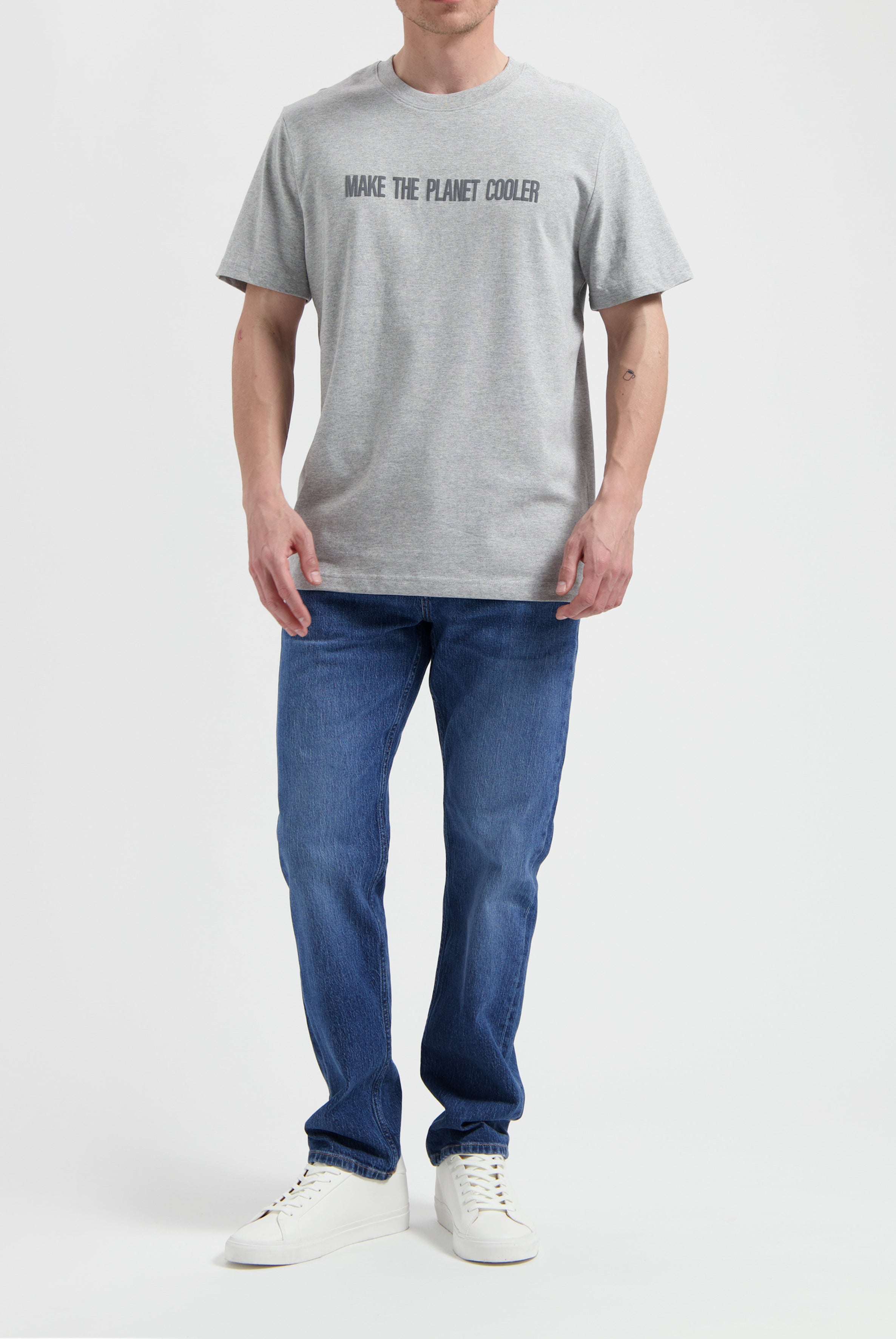 Sustainable MUD Jeans in beige, crafted from organic cotton, showcased with a gray shirt, focusing on ethical fashion.