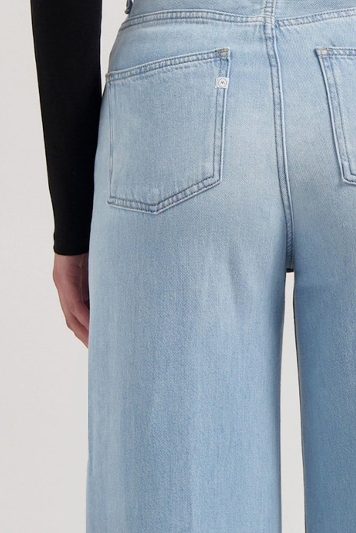 Light blue high-waisted denim jeans shown from the back, featuring wide-leg design and classic pocket stitching.