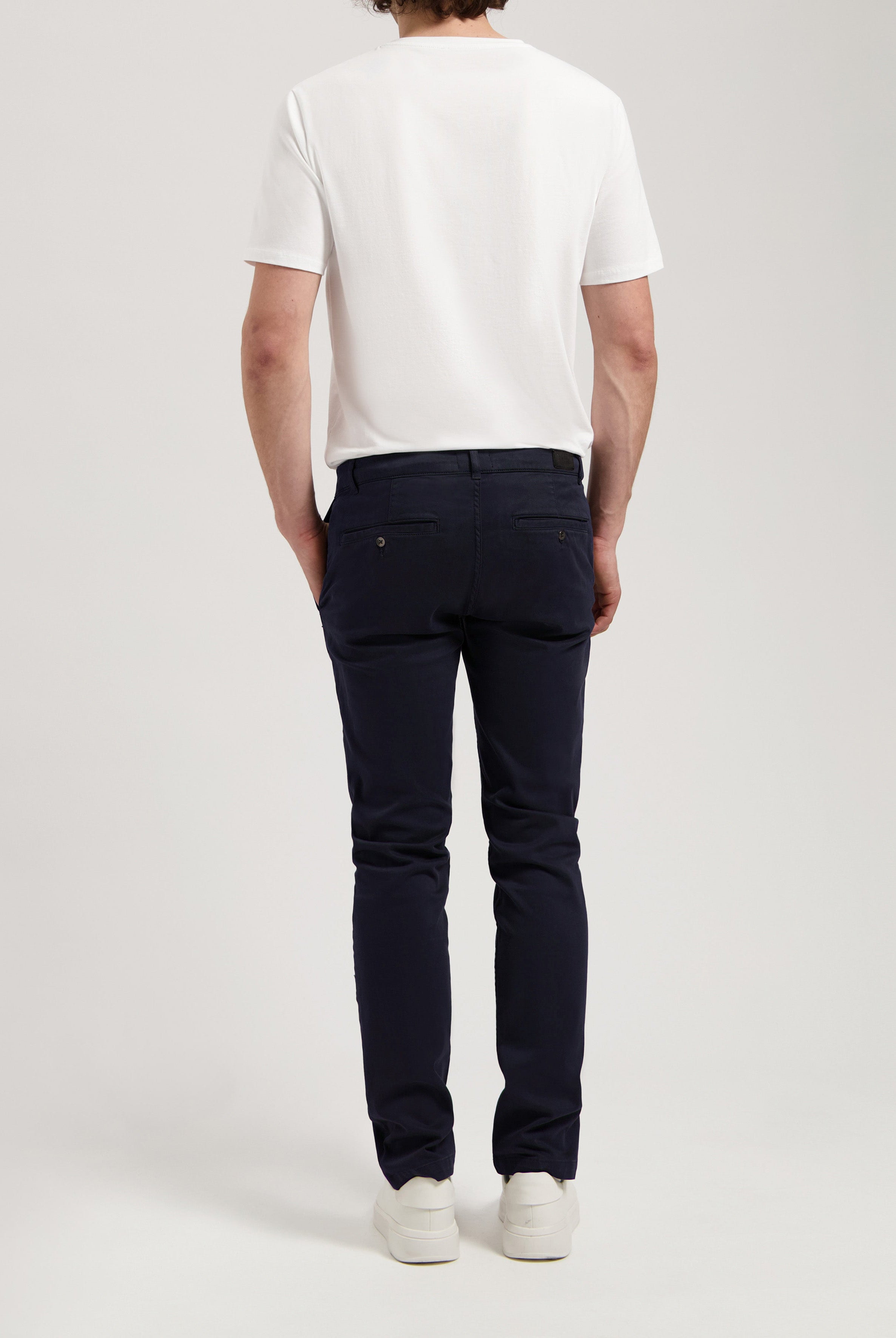 Sustainable MUD Jeans in white organic cotton, showcasing a straight fit, styled with a navy blue shirt.