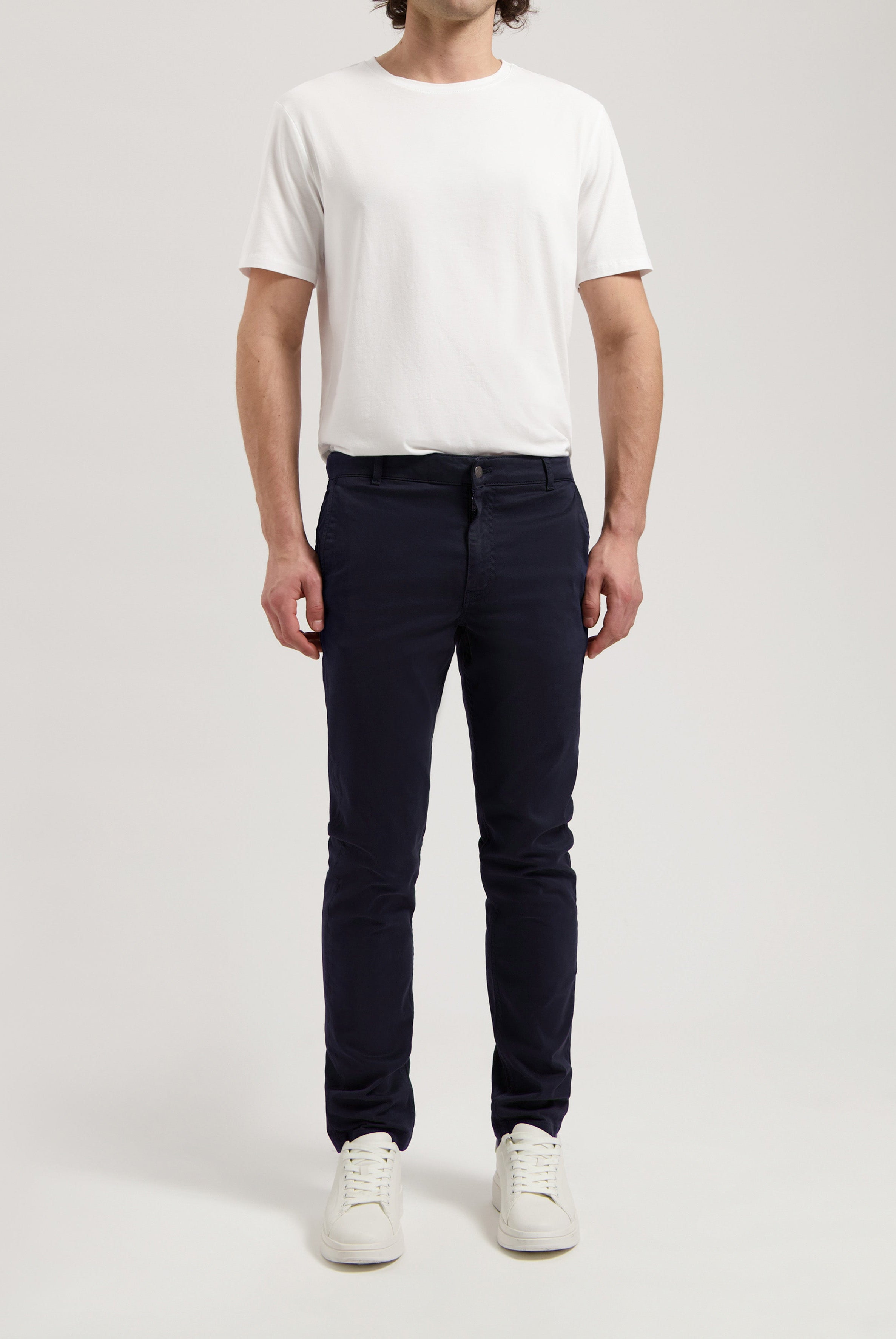 Sustainable MUD Jeans in off-white organic cotton, paired with a navy blue t-shirt, highlighting ethical fashion.