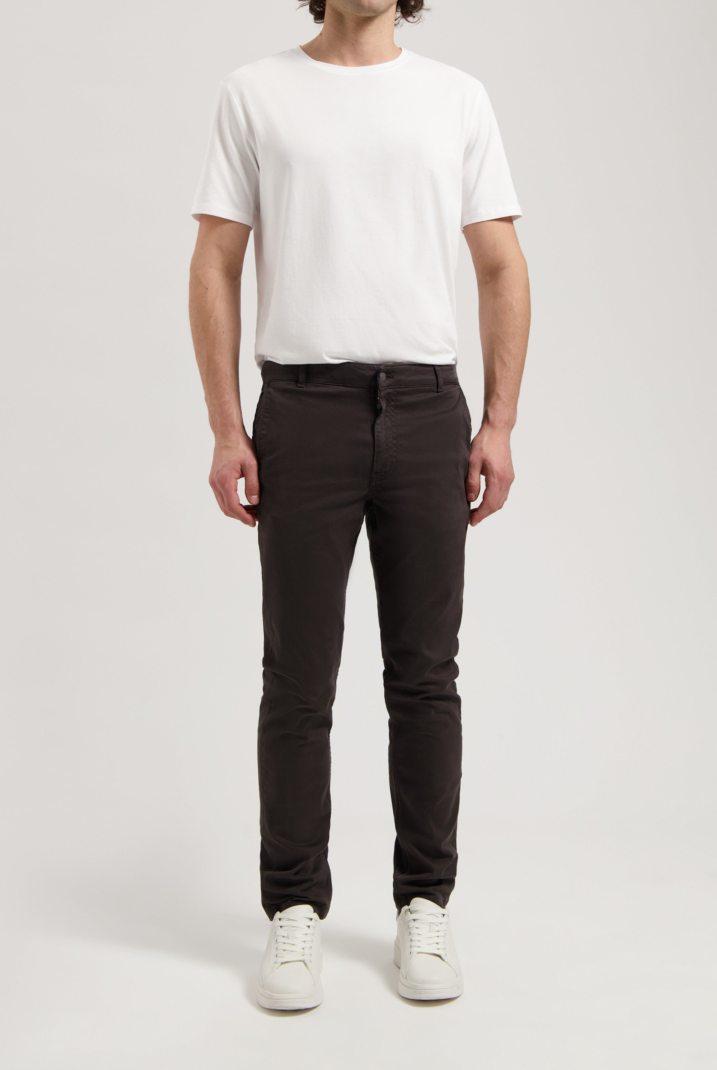 Sustainable MUD Jeans in washed gray, crafted ethically from organic cotton, shown with a white long-sleeve shirt.