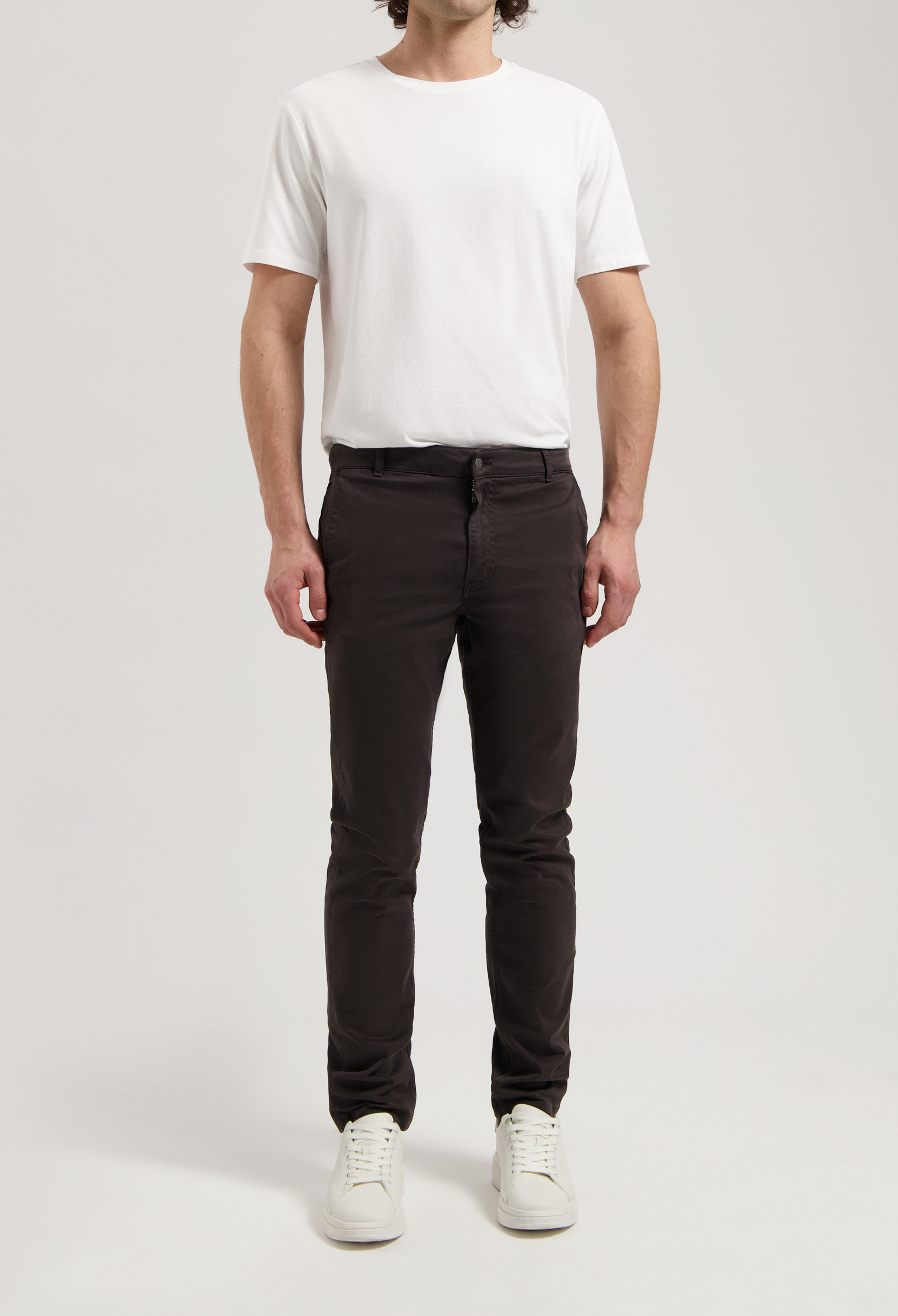 Sustainable MUD Jeans in washed gray, crafted ethically from organic cotton, shown with a white long-sleeve shirt.