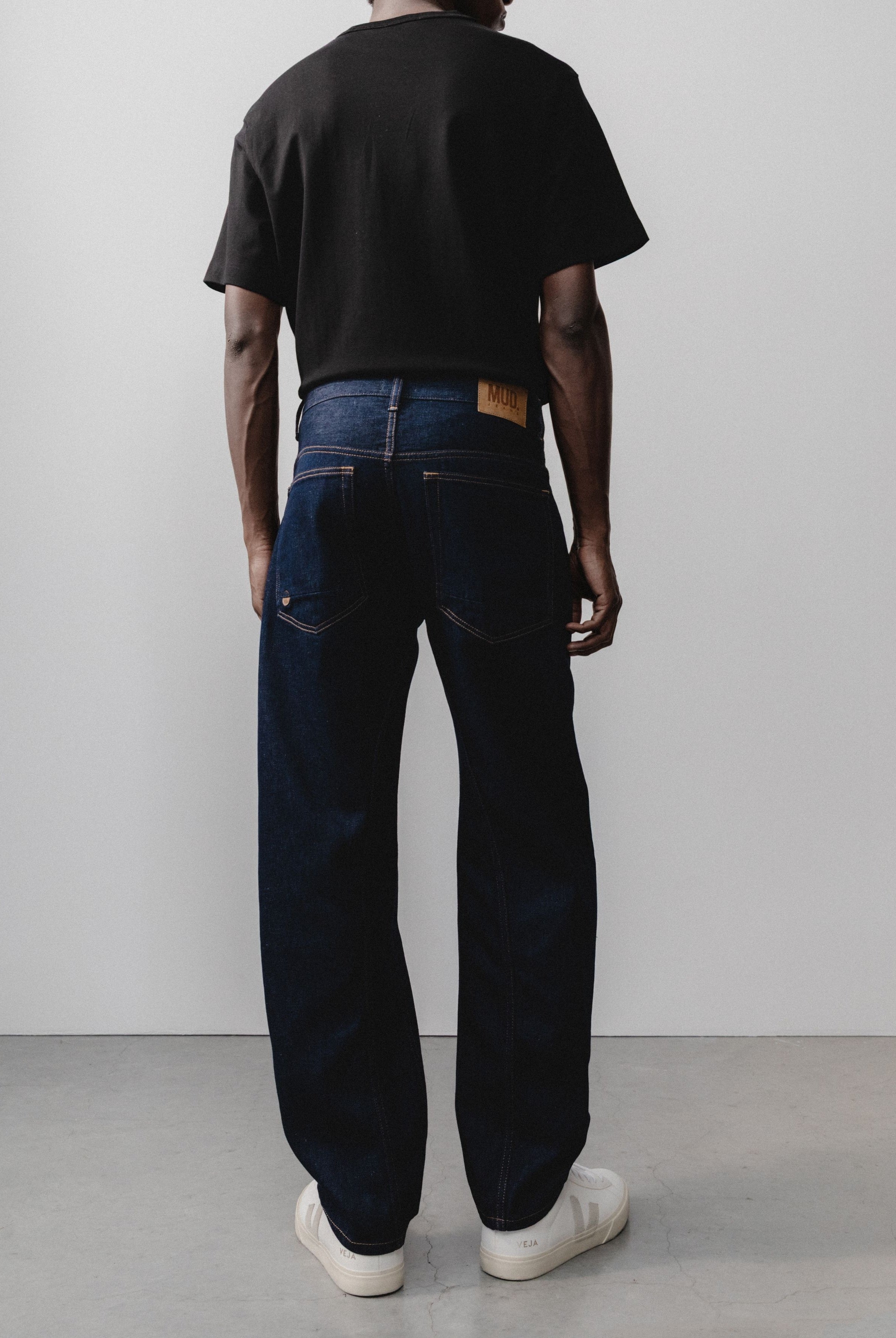 Sustainable MUD Jeans crafted from light blue organic cotton denim, paired with a plain white t-shirt for an ethical style.