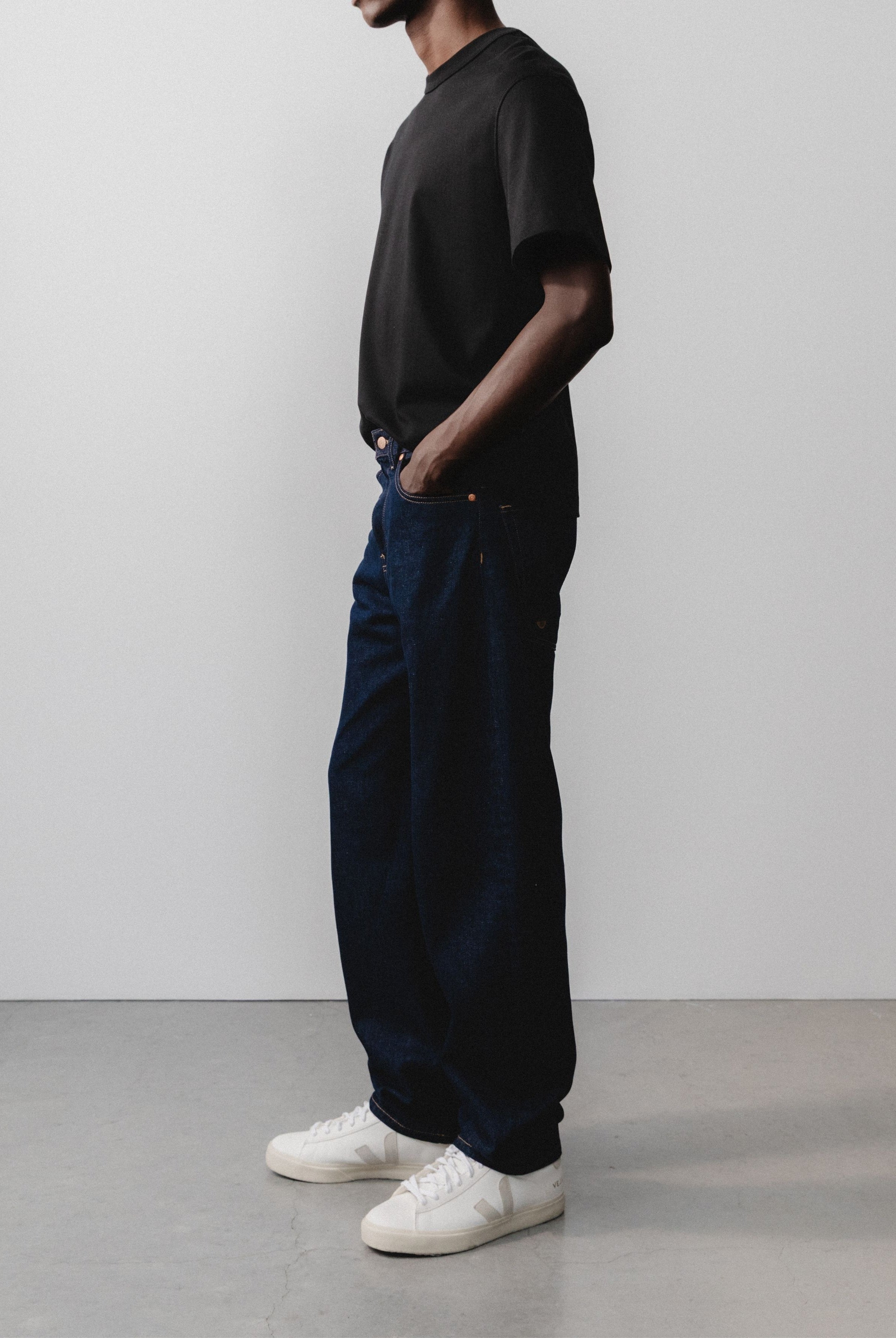 Sustainable MUD Jeans in light blue denim, featuring a classic fit paired with a white t-shirt for an ethical style.