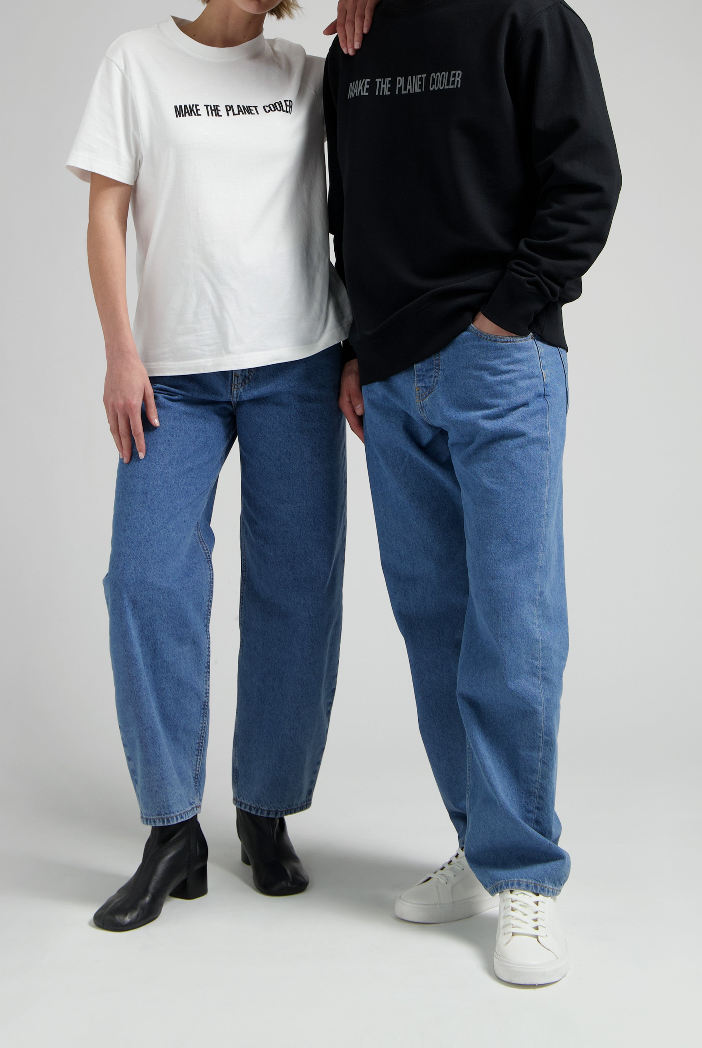 Casual fashion with eco-friendly T-shirts, one in white and one in black, paired with blue jeans and stylish footwear.