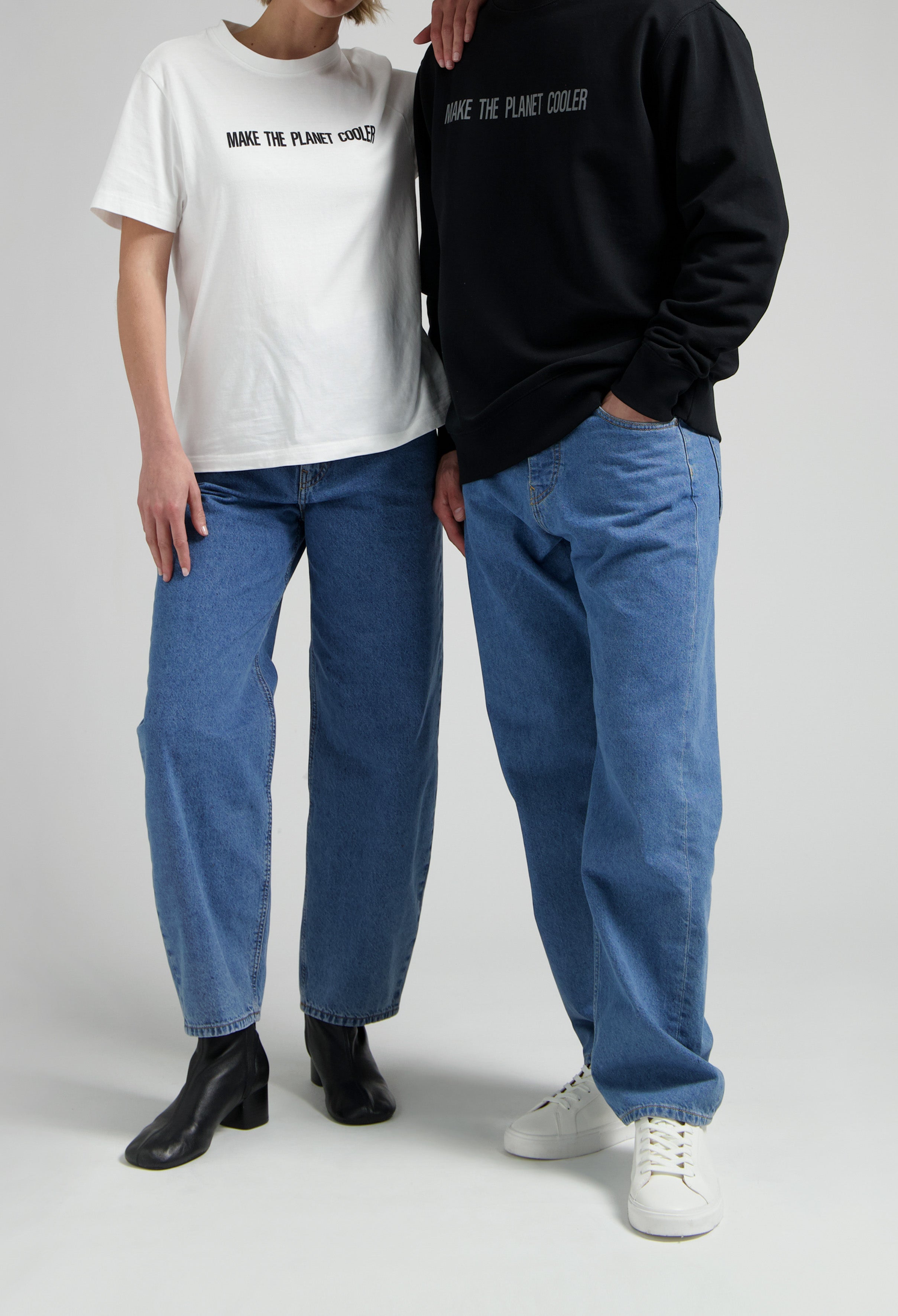 Casual fashion with eco-friendly T-shirts, one in white and one in black, paired with blue jeans and stylish footwear.