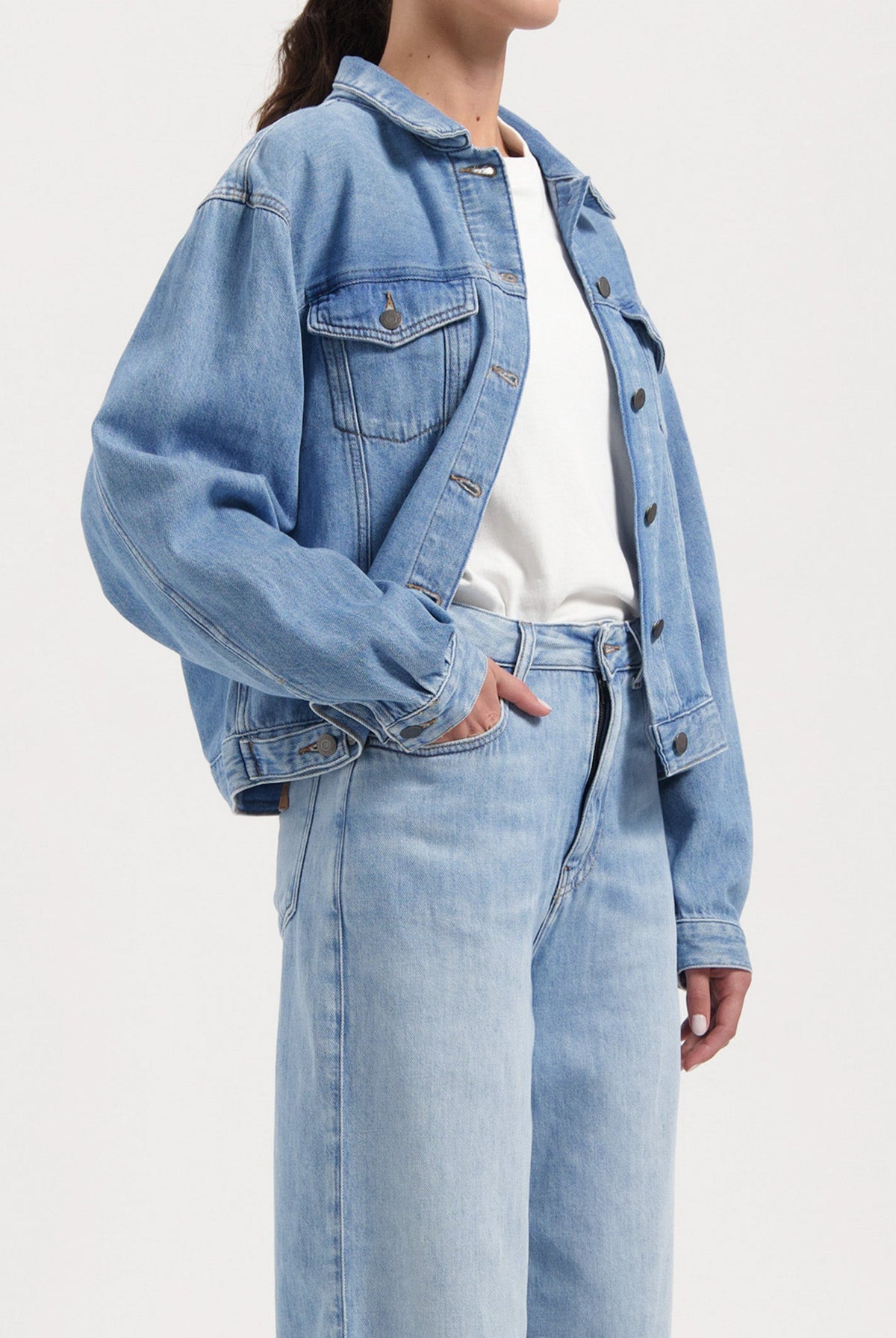 Light blue denim jacket and high-waisted jeans, featuring a casual fit, styled with a white T-shirt for a relaxed look.