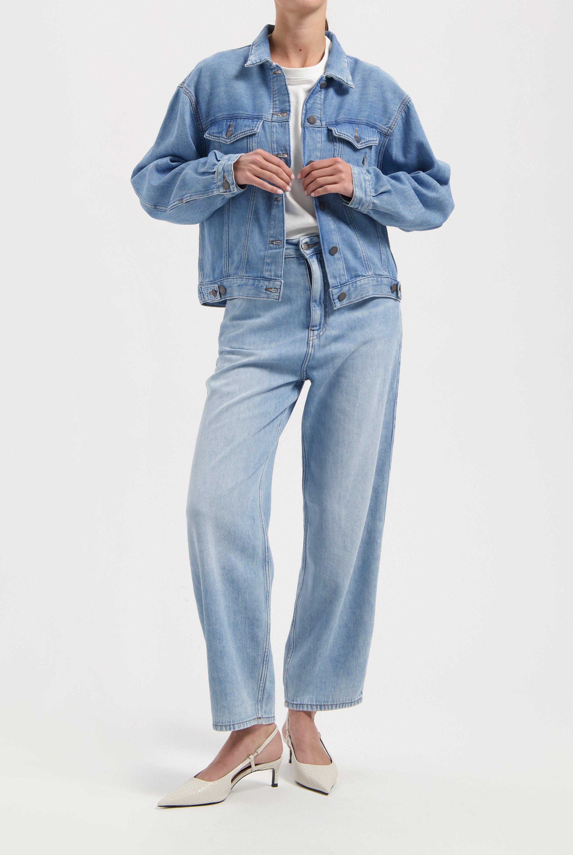 Light blue denim jacket and jeans set with relaxed fit, paired with a white tee and stylish cream slingback heels.