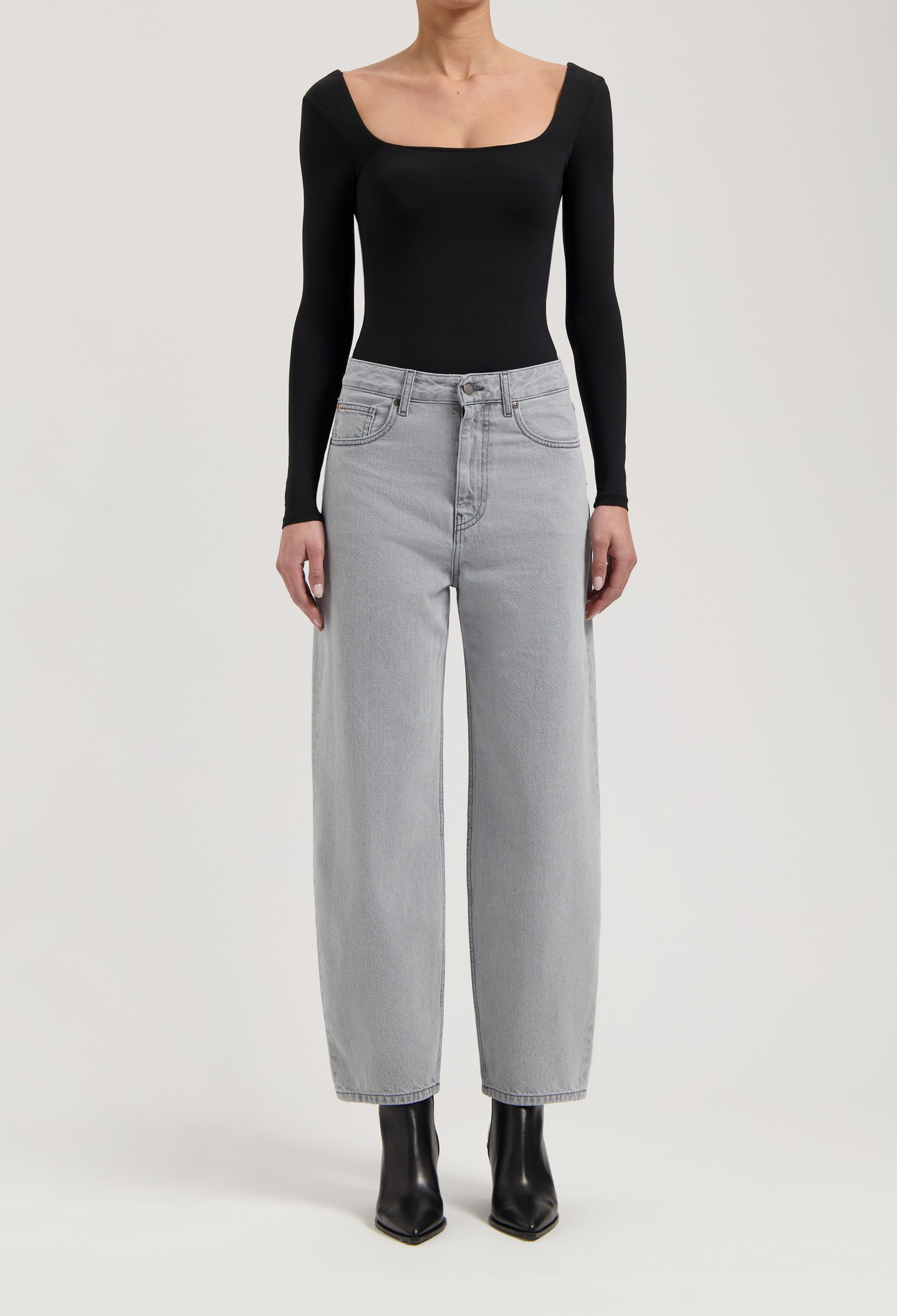 Casual high-waisted gray wide-leg jeans paired with a fitted black long-sleeve top and sleek black ankle boots.