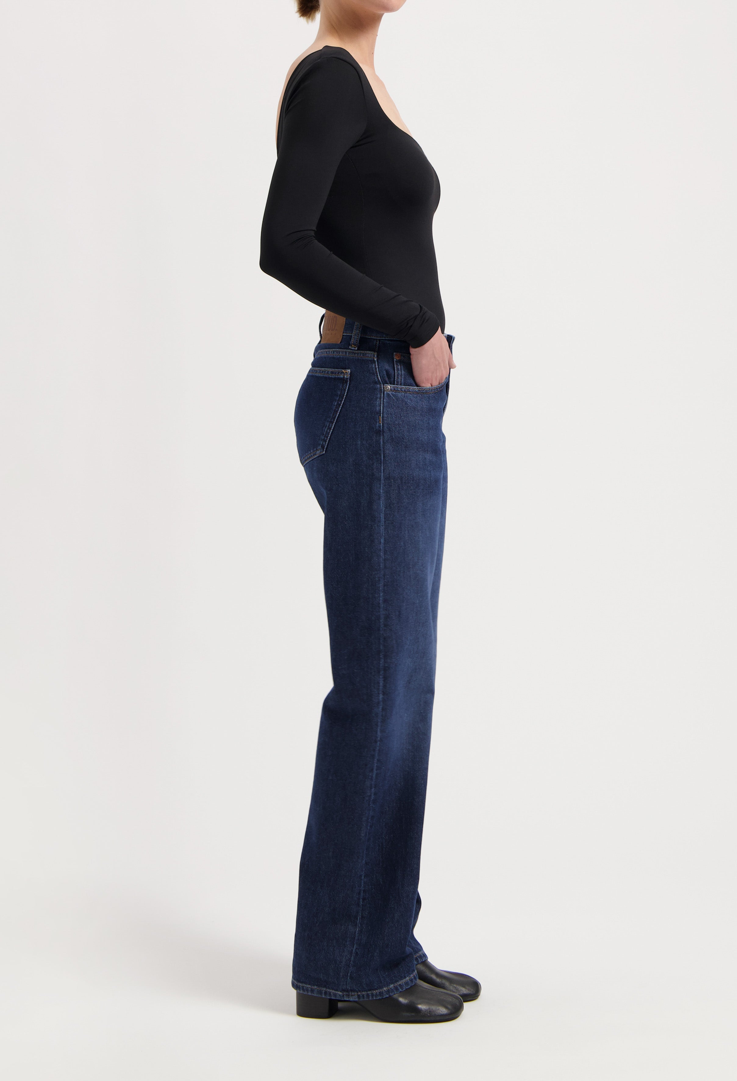 Wide-leg dark blue jeans paired with a black long-sleeve top, showcasing a casual and stylish outfit.