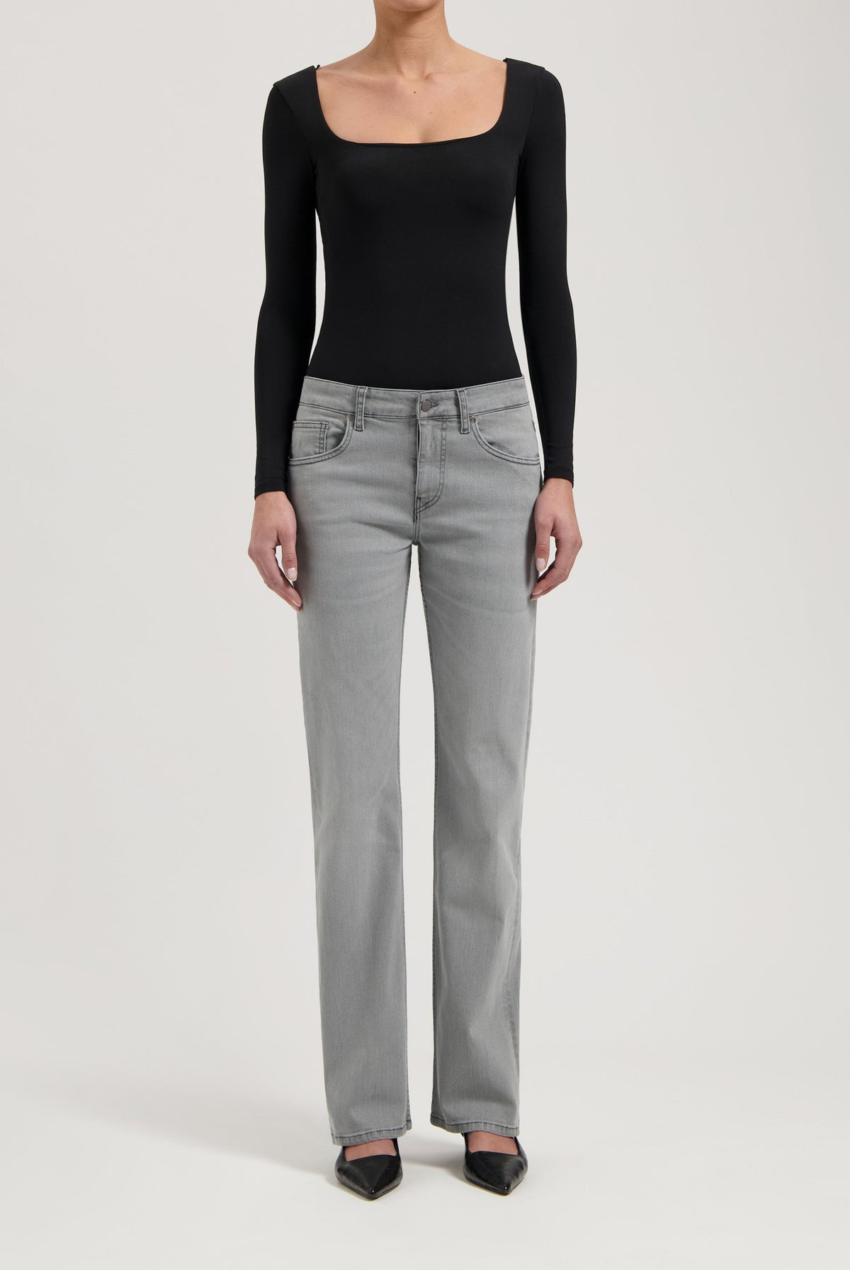 Women's gray straight-leg jeans paired with a black long-sleeve bodysuit, showcasing casual chic fashion style.