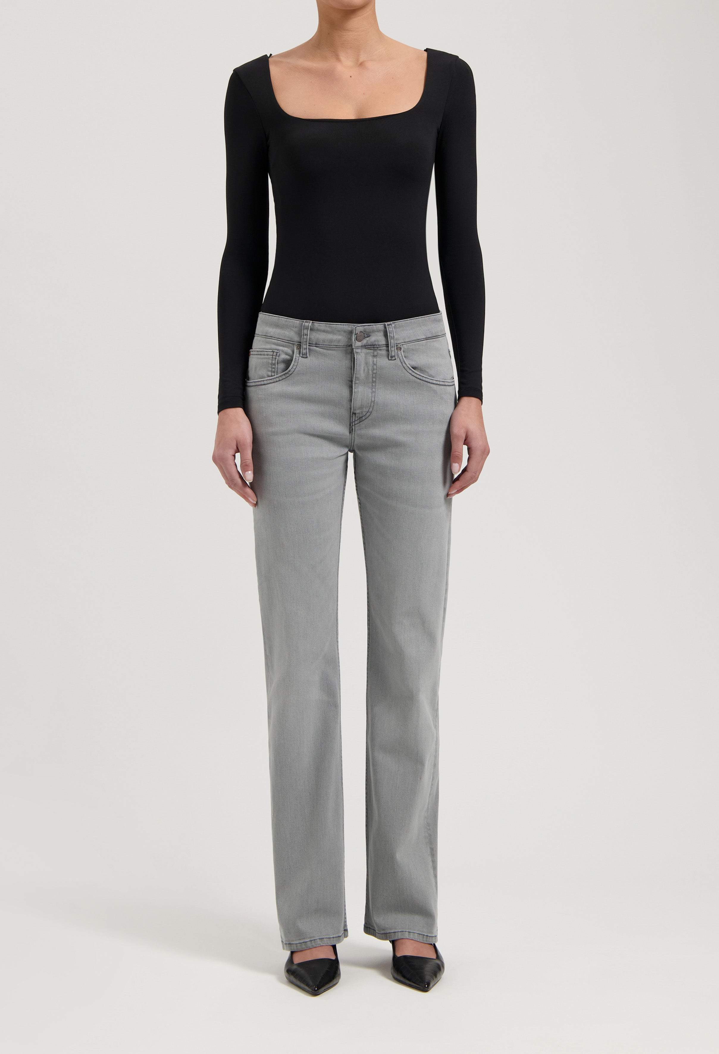 Women's gray straight-leg jeans paired with a black long-sleeve bodysuit, showcasing casual chic fashion style.