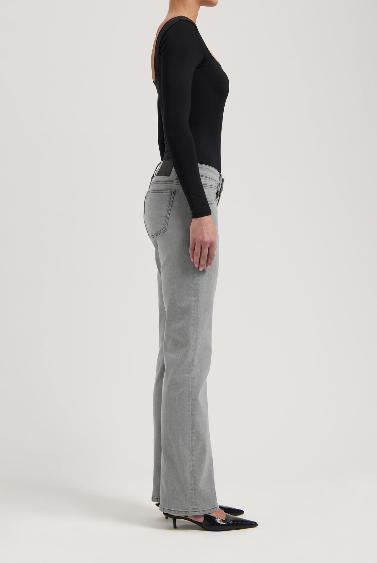 Figure-flattering gray bootcut jeans paired with a sleek black long-sleeve top, showcasing a modern casual outfit.