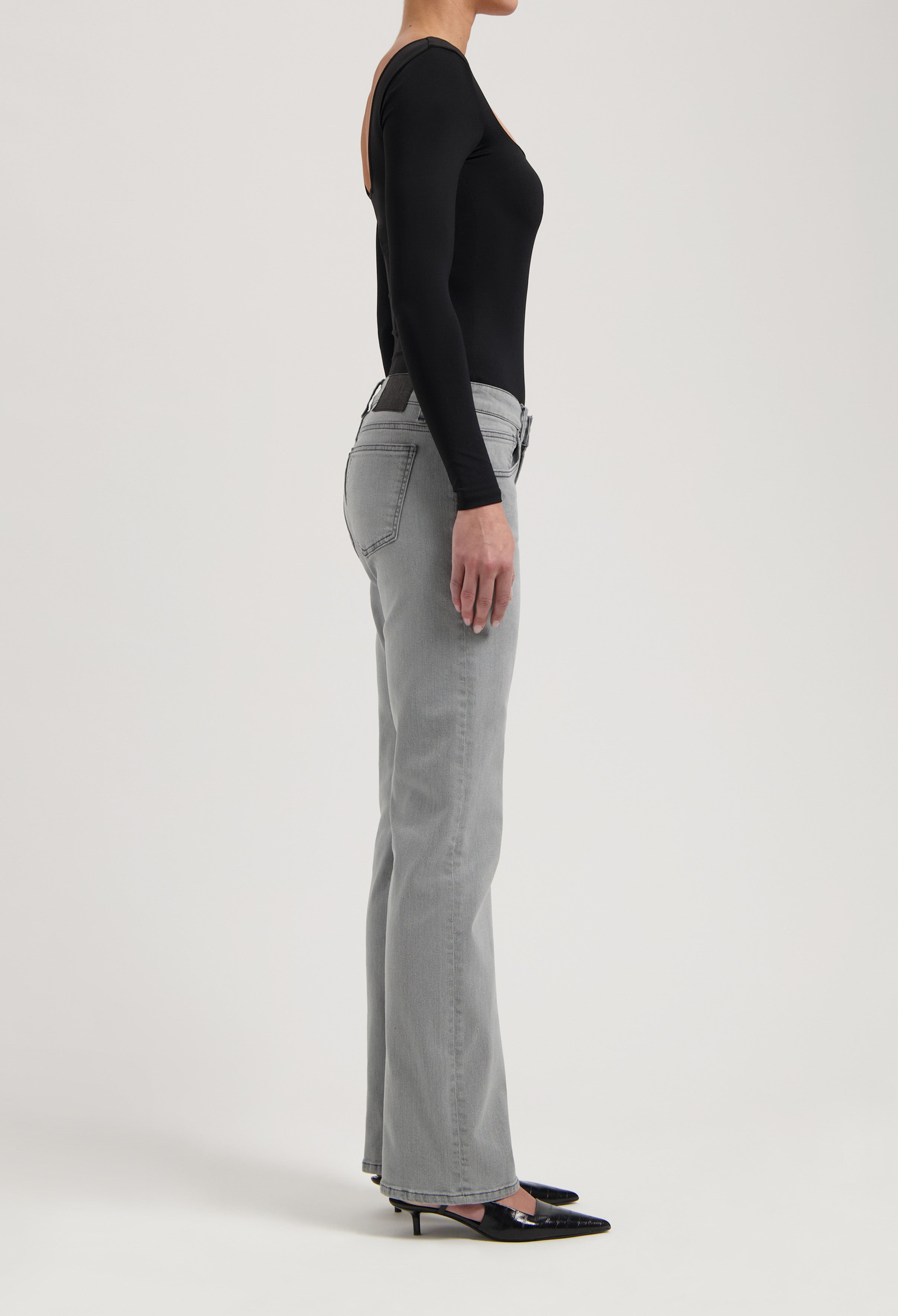 Figure-flattering gray bootcut jeans paired with a sleek black long-sleeve top, showcasing a modern casual outfit.