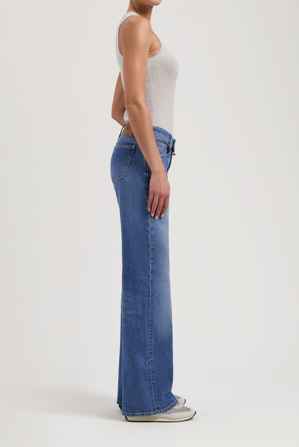 High-waisted, straight-leg blue jeans with a casual gray sleeveless tank top, showcasing modern casual wear style.
