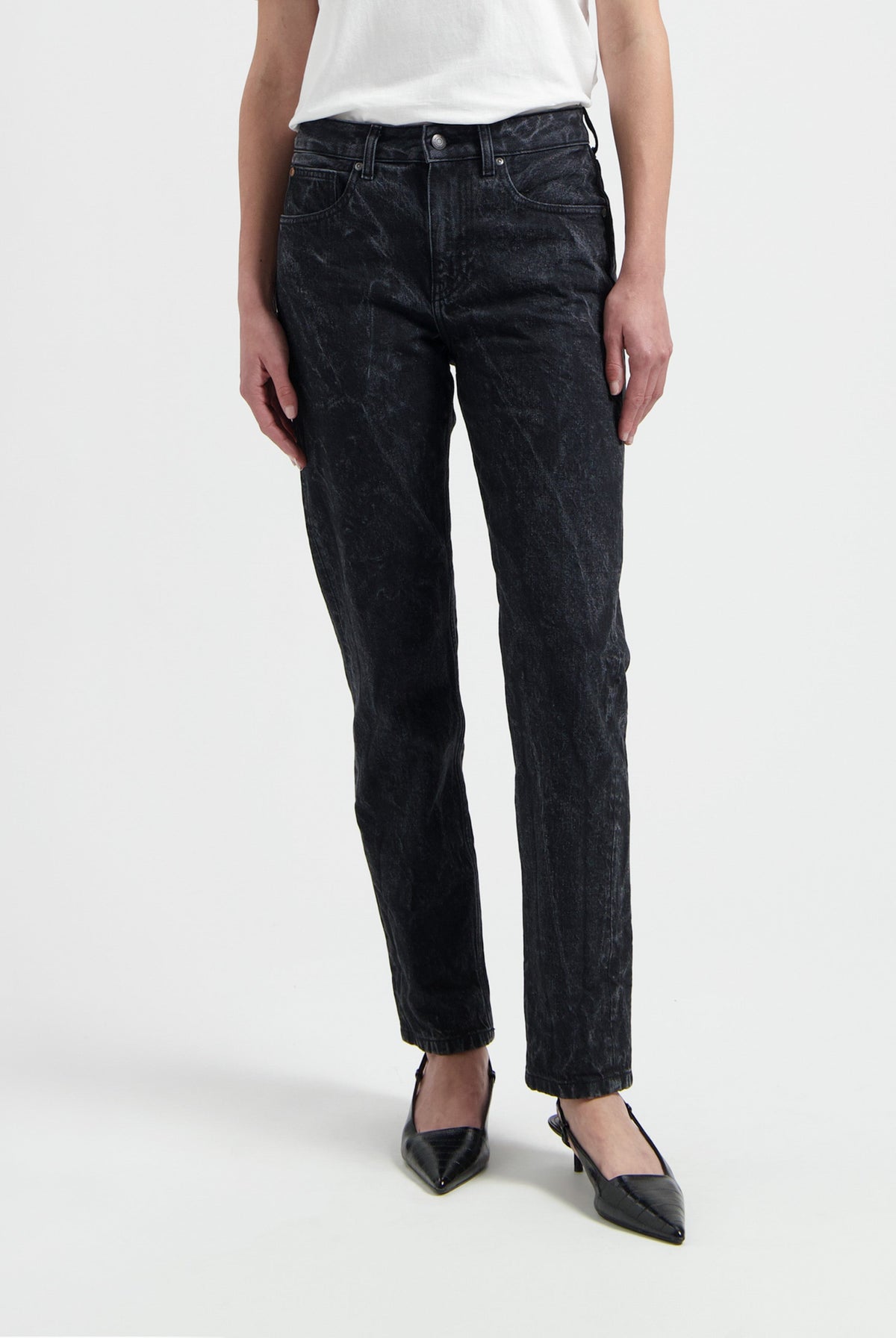 Stylish black denim jeans paired with a simple white t-shirt and black pointed heels, showcasing a casual chic look.