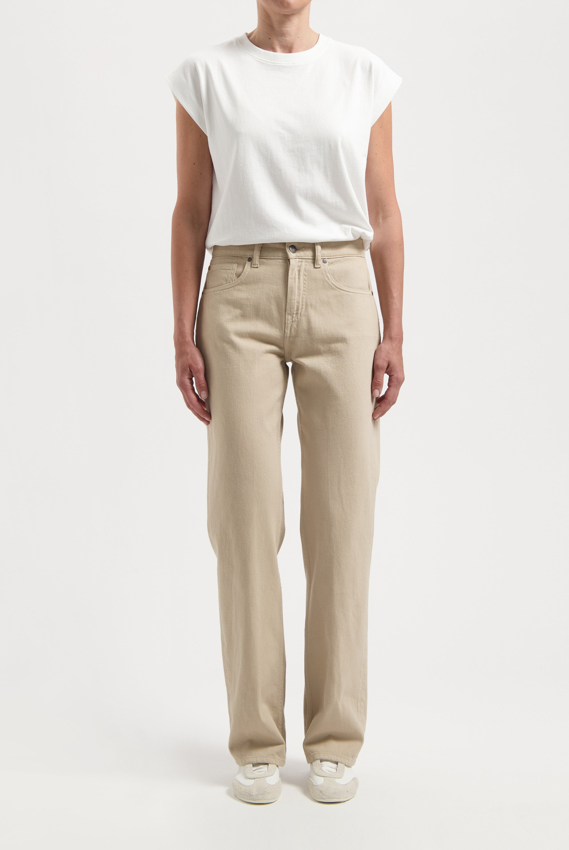 Casual beige straight-leg pants paired with a white short-sleeve top, highlighting relaxed fit and minimalist style.