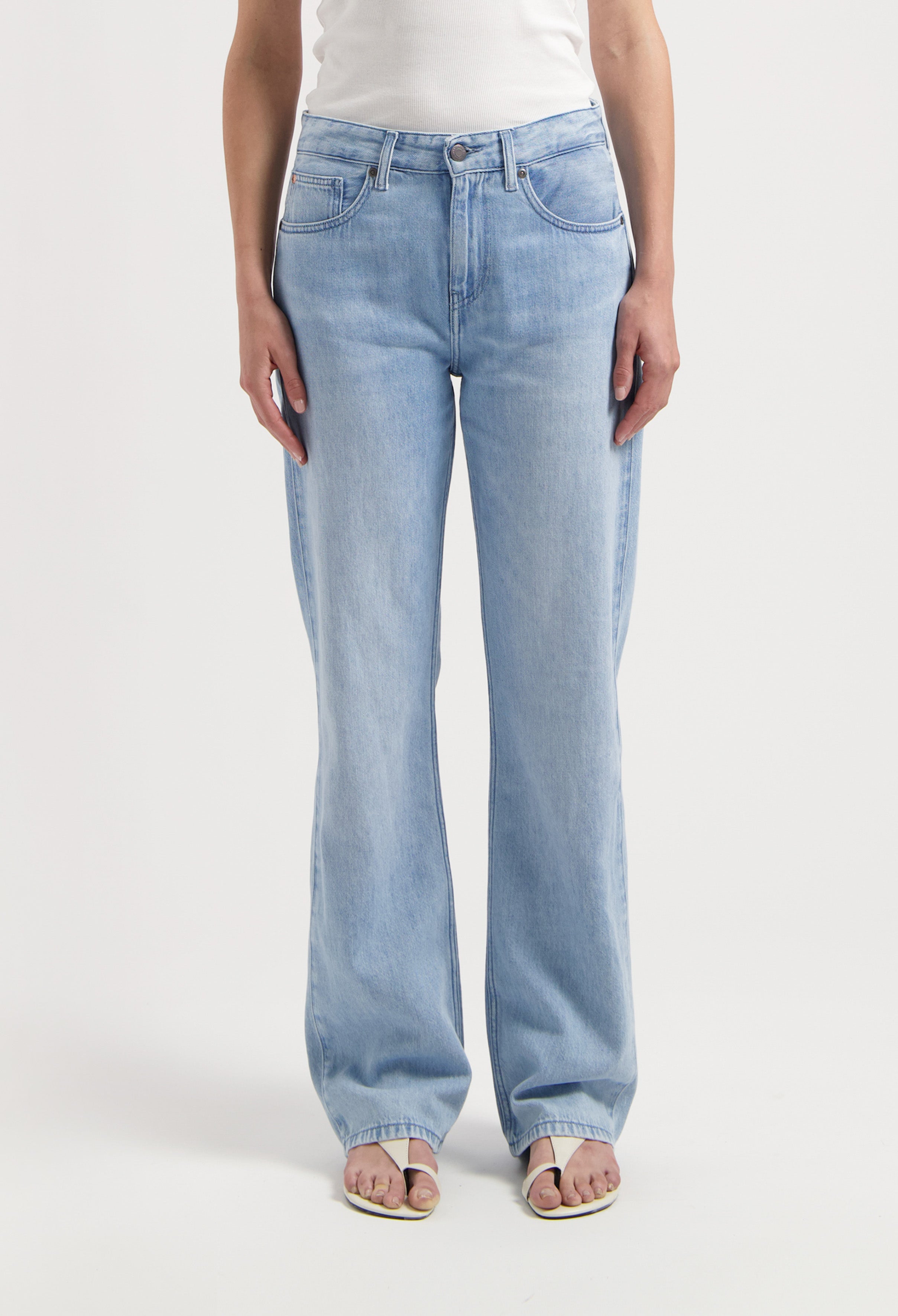 Light blue, high-waisted wide-leg denim jeans, featuring classic five-pocket design, casually paired with a white tank top.