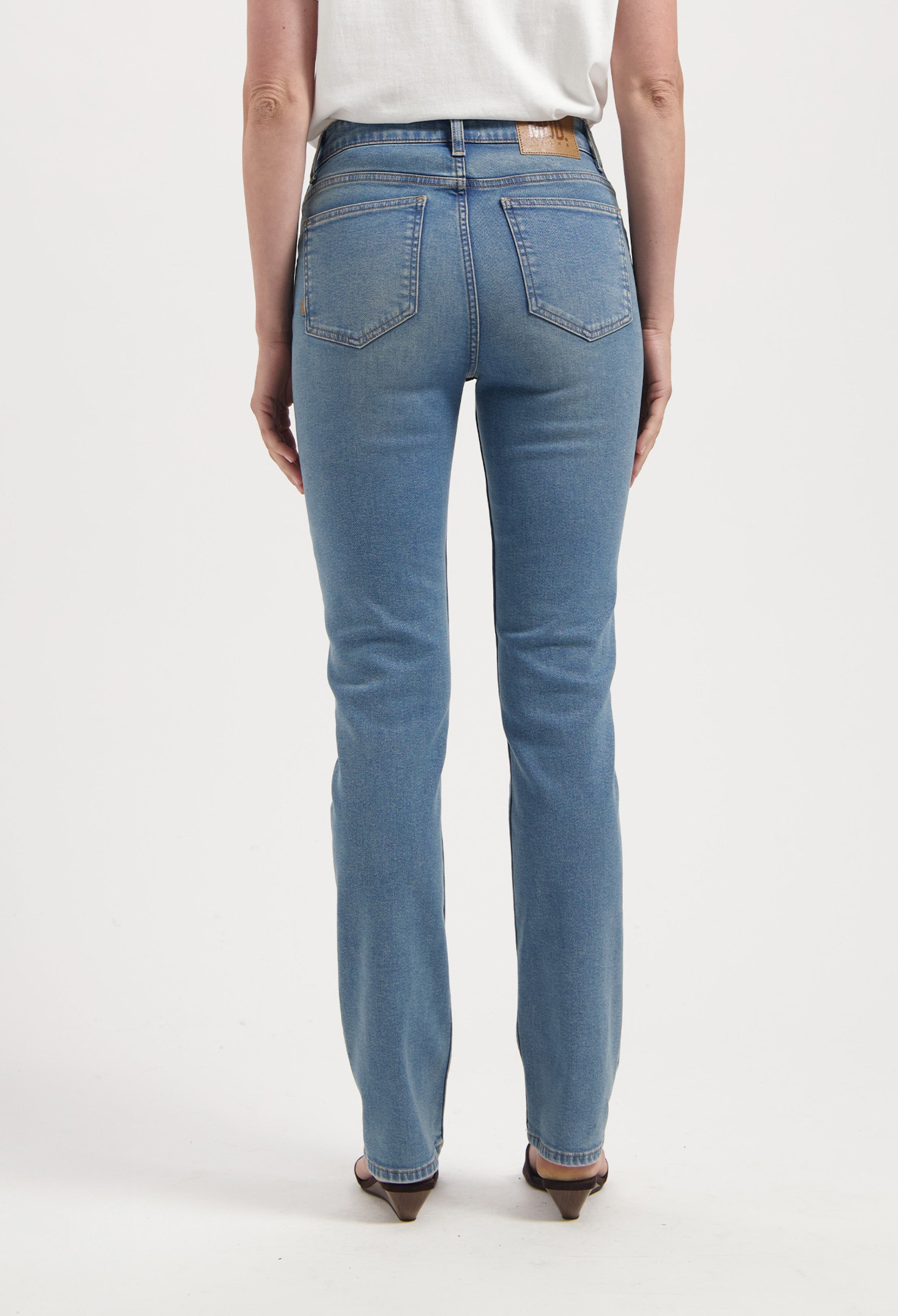 High-waisted light blue denim jeans with straight-leg fit, showcasing back pockets and worn with a tucked-in white tee.