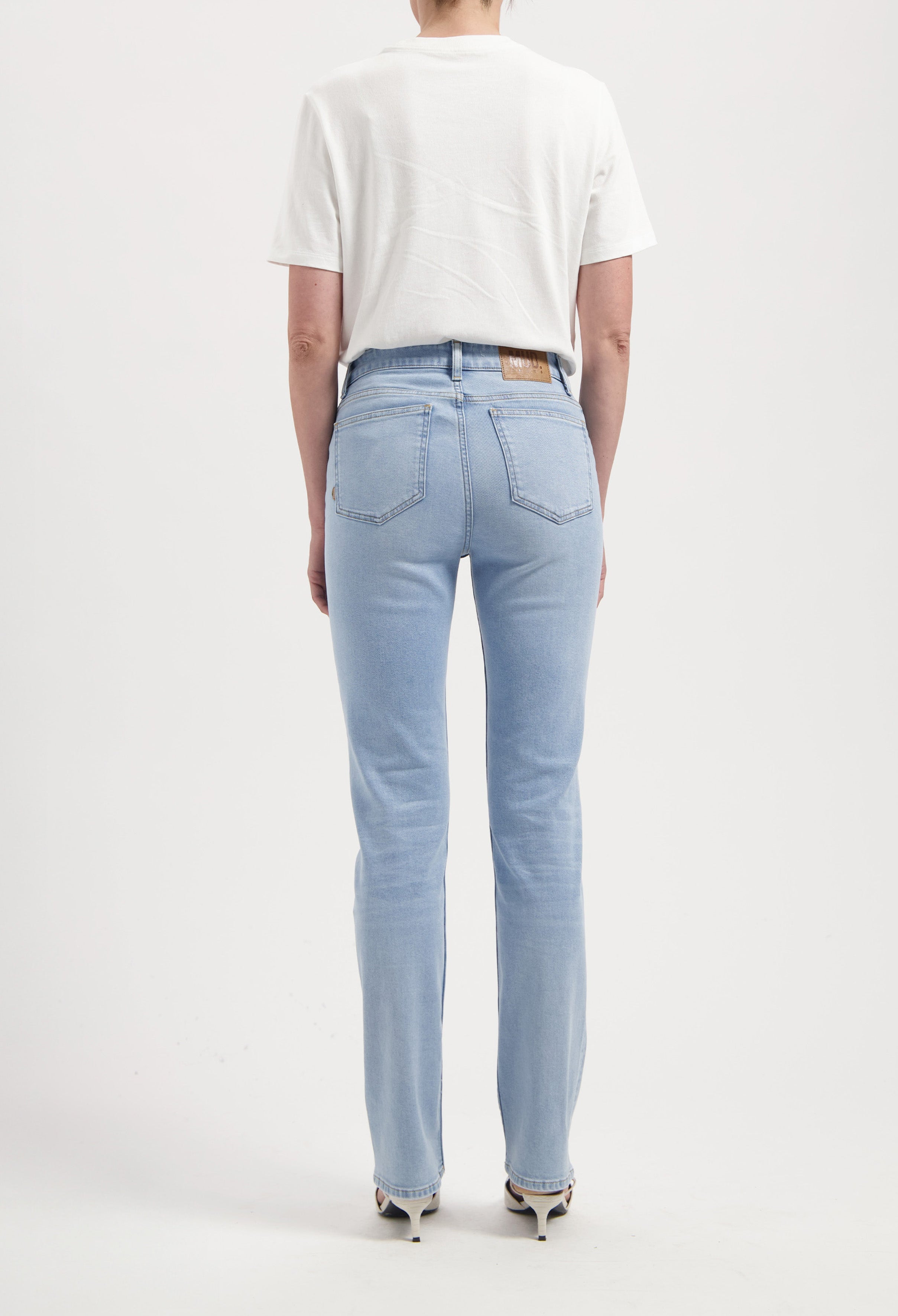 Light blue slim-fit jeans made from organic cotton, featuring a back view worn with a plain white short-sleeve t-shirt.
