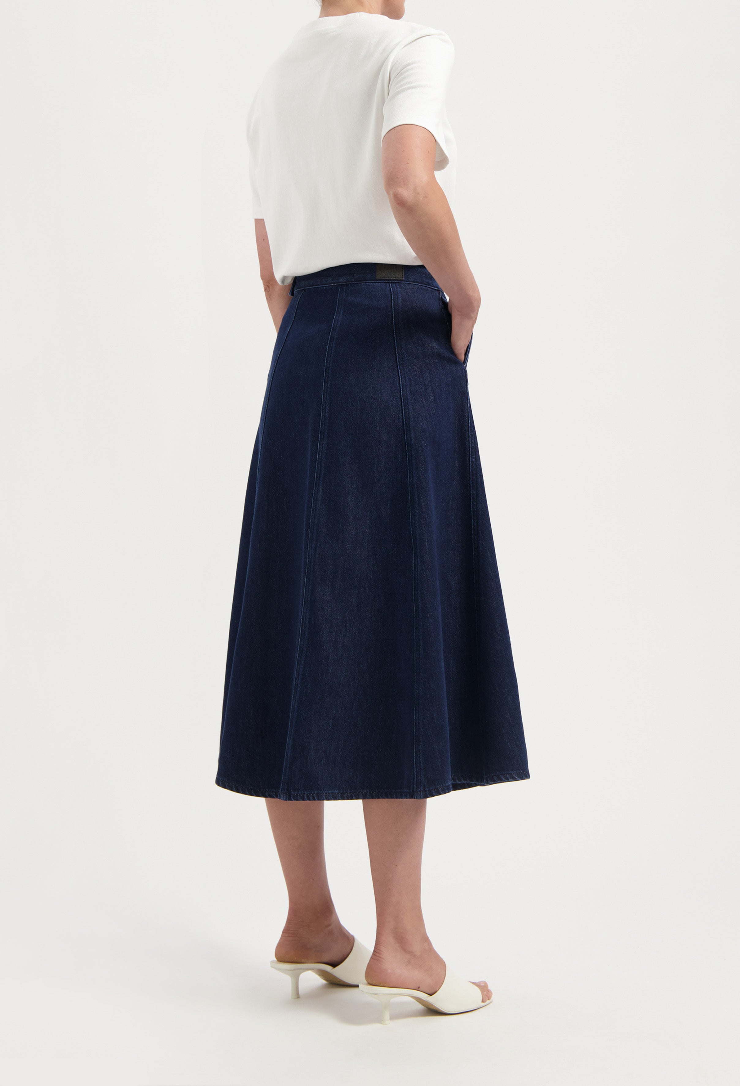 A-line dark blue denim skirt paired with a white top, showcasing stylish and simple summer fashion.