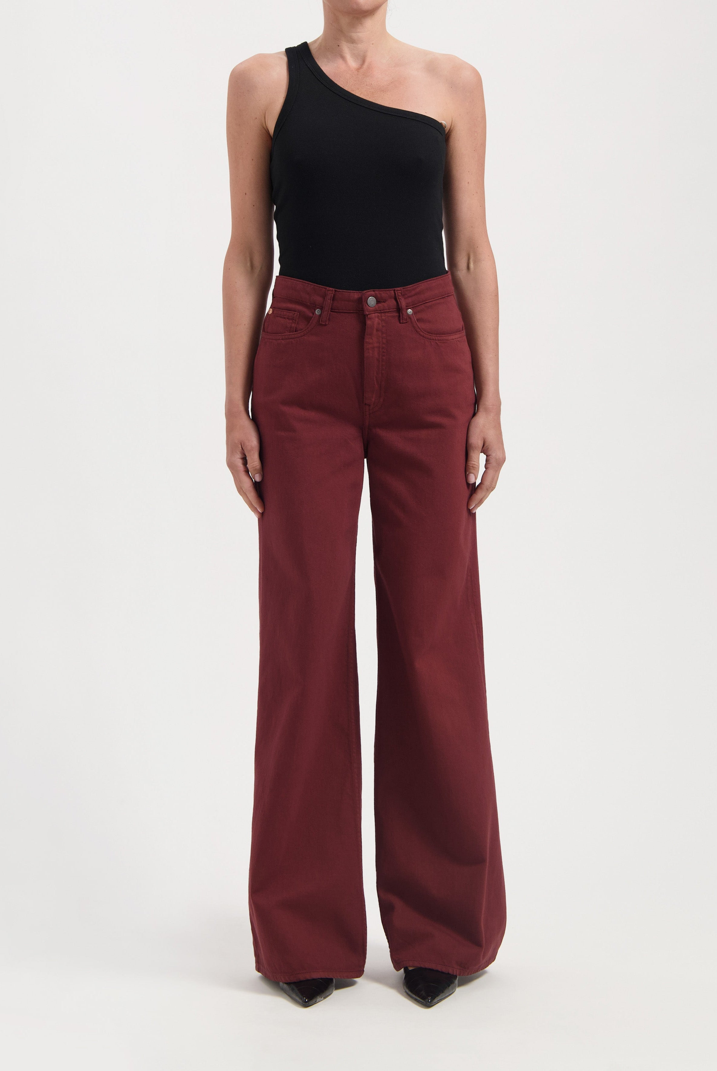 Wide-leg burgundy cotton pants with high waist, paired with a black one-shoulder top, showcasing modern casual style.