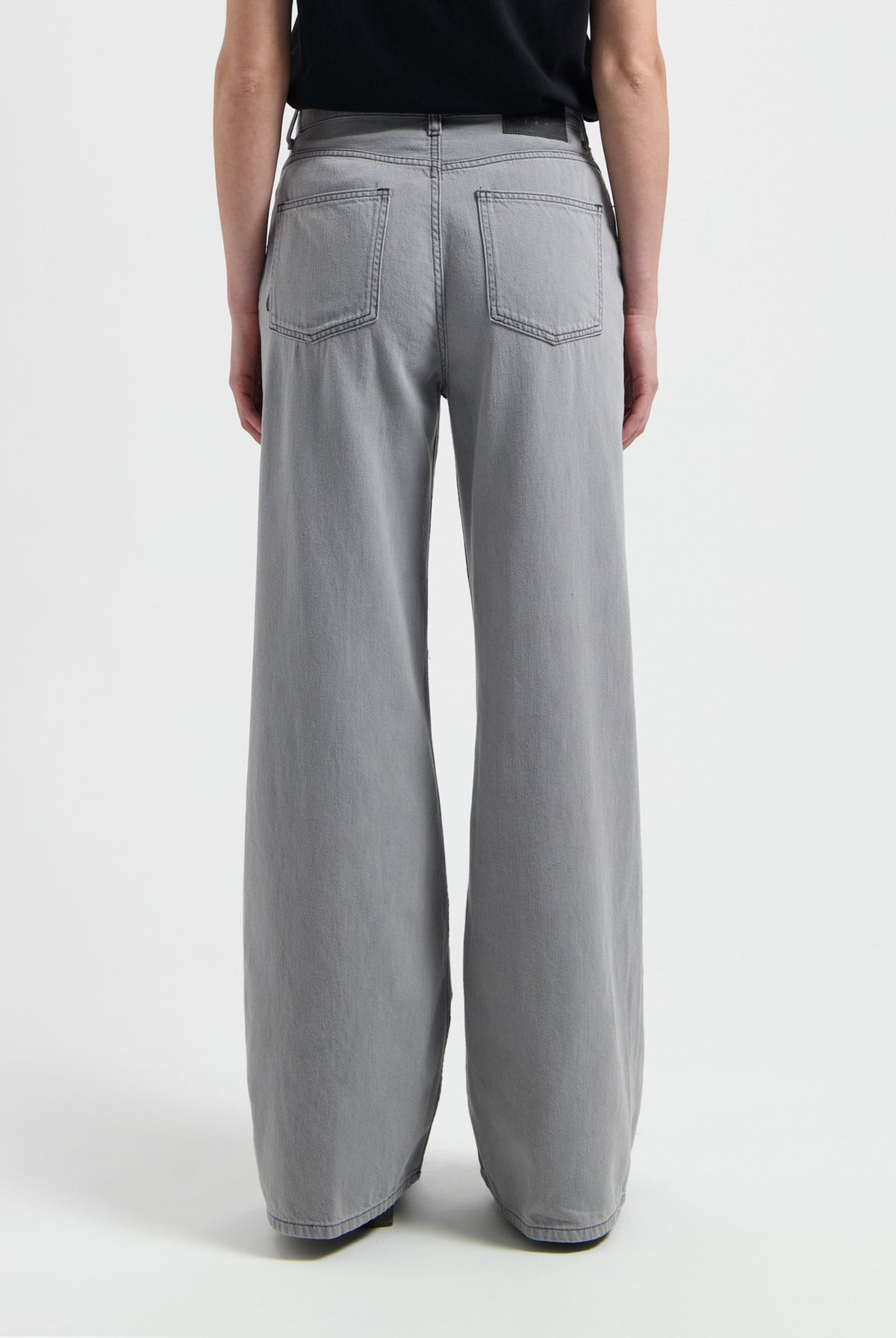 Wide-leg gray jeans made from cotton, featuring a high-waist design, shown from the back with visible pocket stitching.