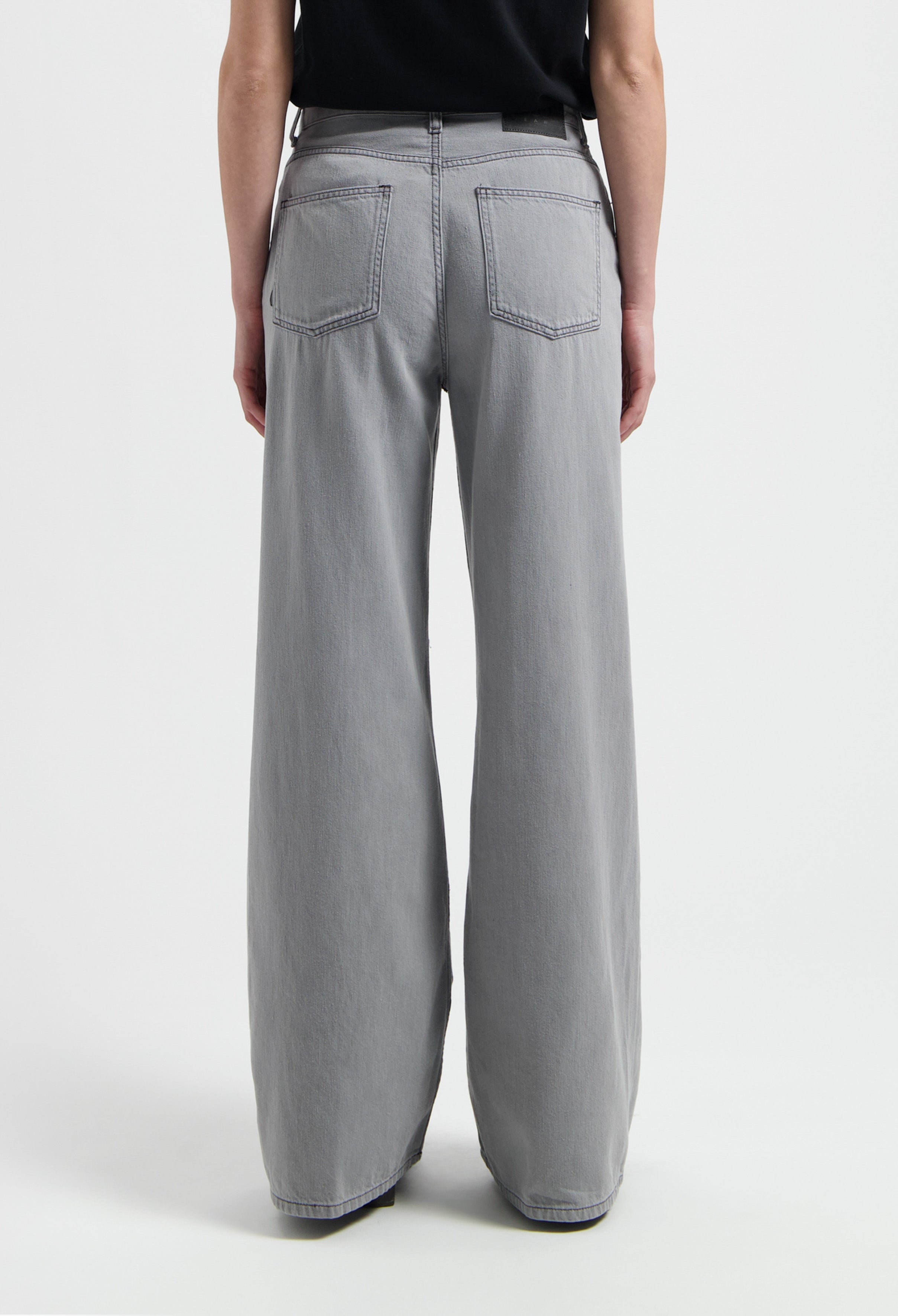 Wide-leg gray jeans made from cotton, featuring a high-waist design, shown from the back with visible pocket stitching.