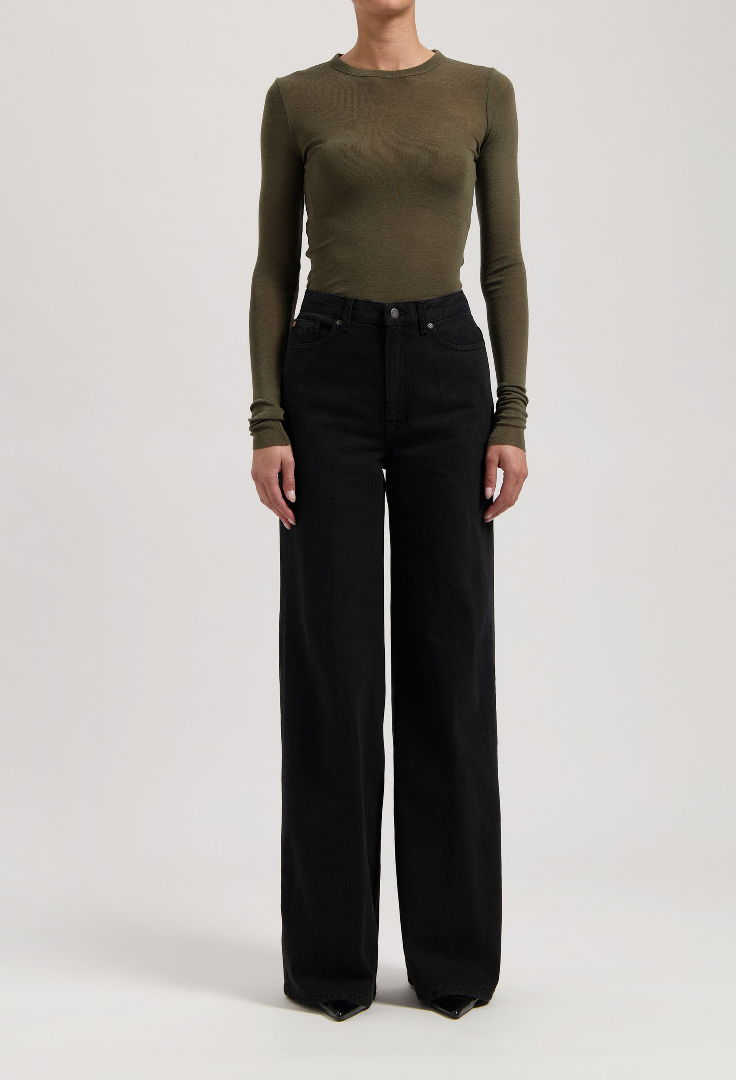 Olive long-sleeve fitted top paired with high-waisted black wide-leg jeans, showcasing casual and chic fashion style.