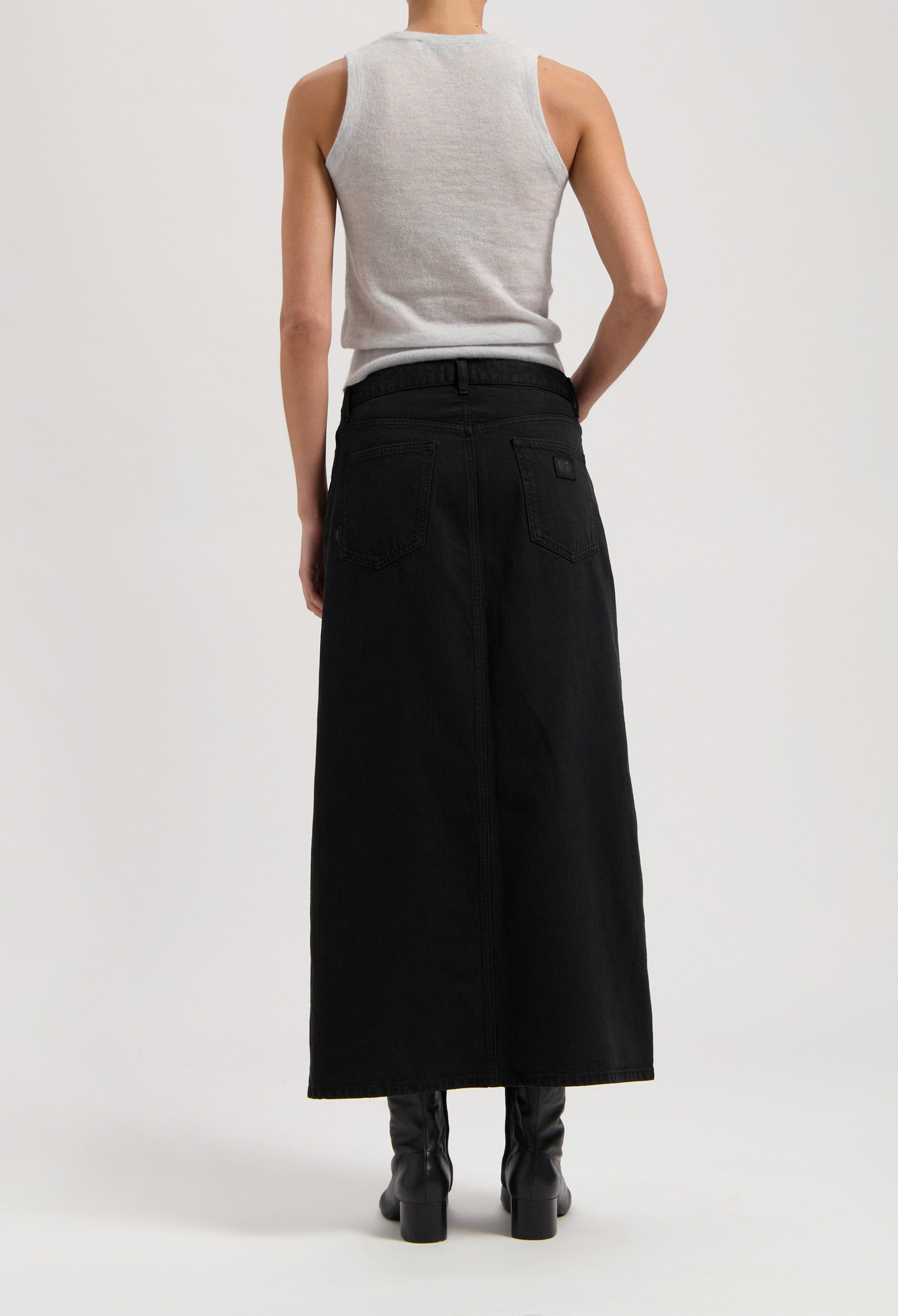 Sleeveless gray top with long black denim maxi skirt, showcasing back style with visible stitching and belt loops.